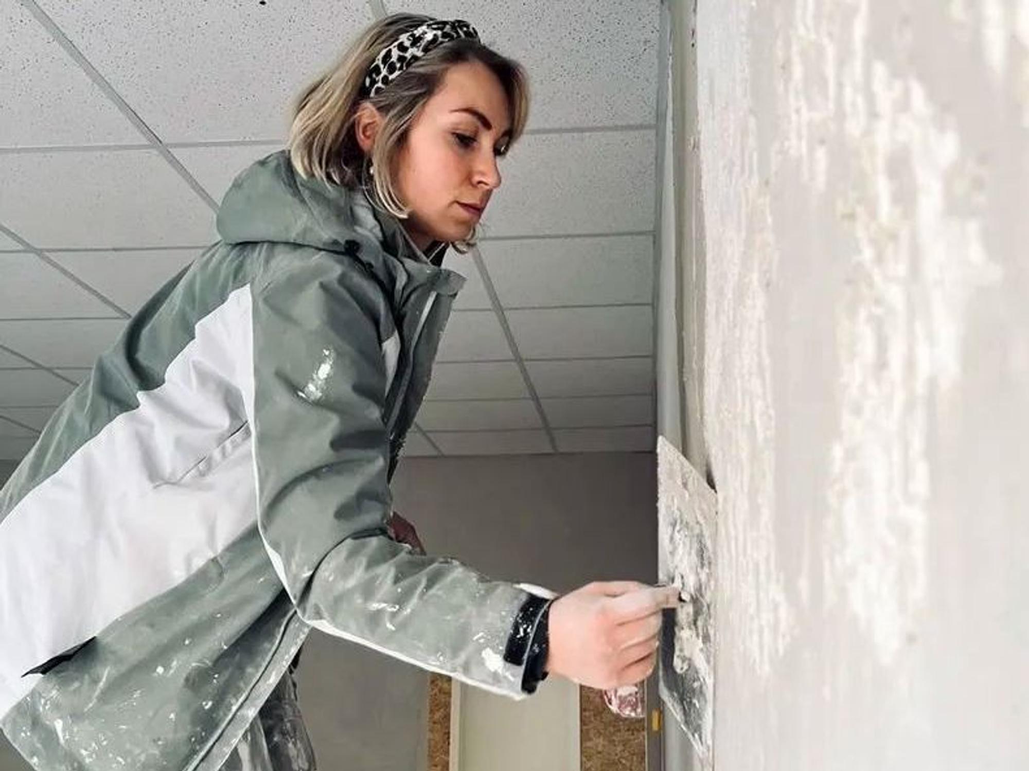Jenny Dollinger verputzt eine Wand.