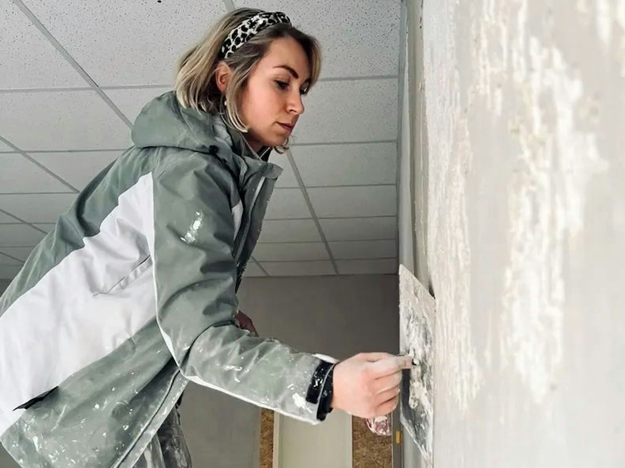 Jenny Dollinger verputzt eine Wand.