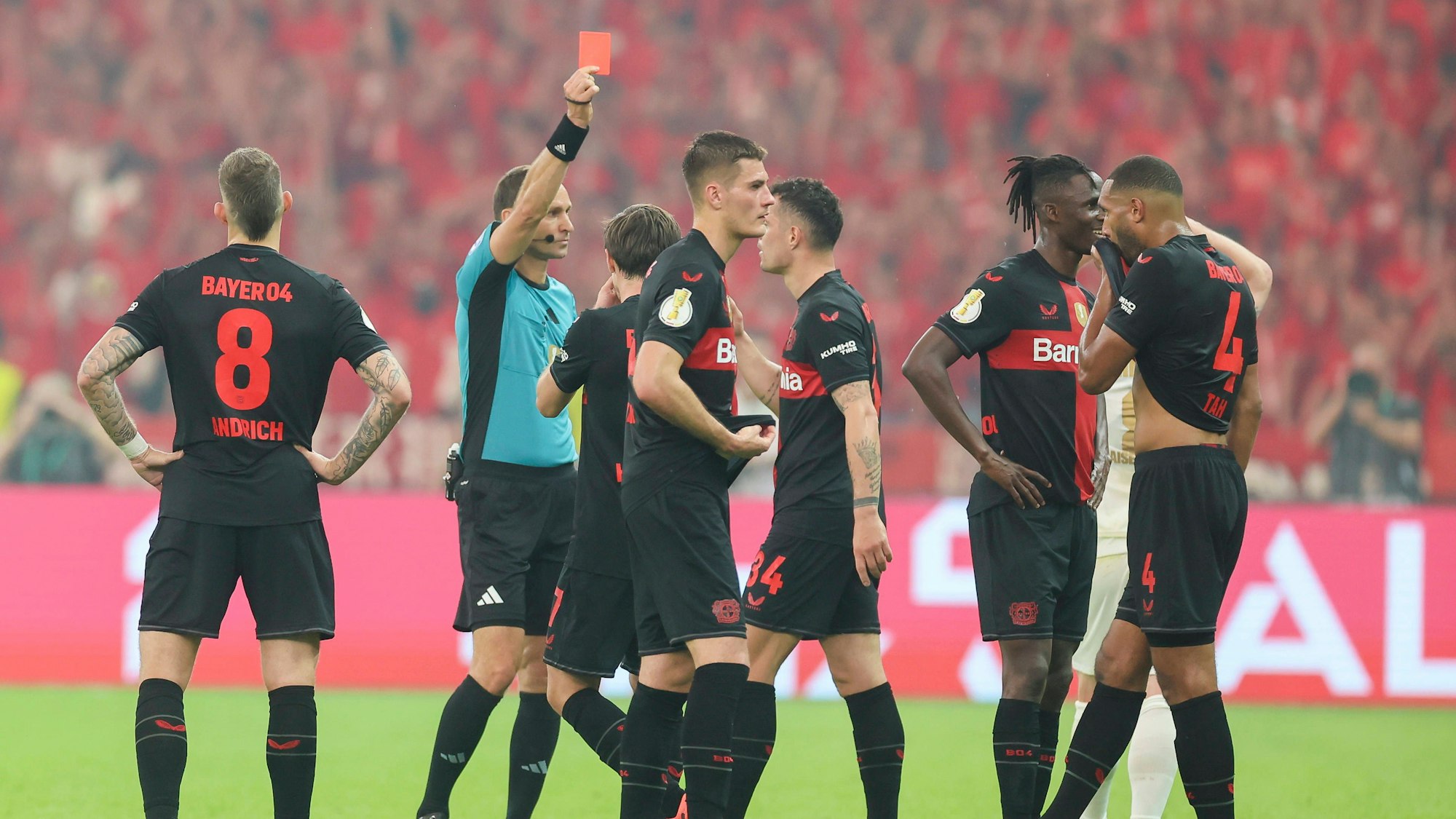 Schiedsrichter Bastian Dankert zeigt Odilon Kossounou (2.v.r.) die Gelb-Rote Karte.