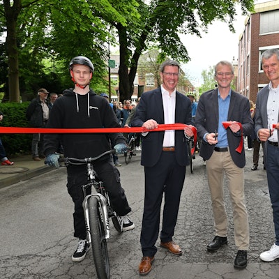 Drei Männer durchschneiden ein rotes Band auf dem zanders-Gelände.