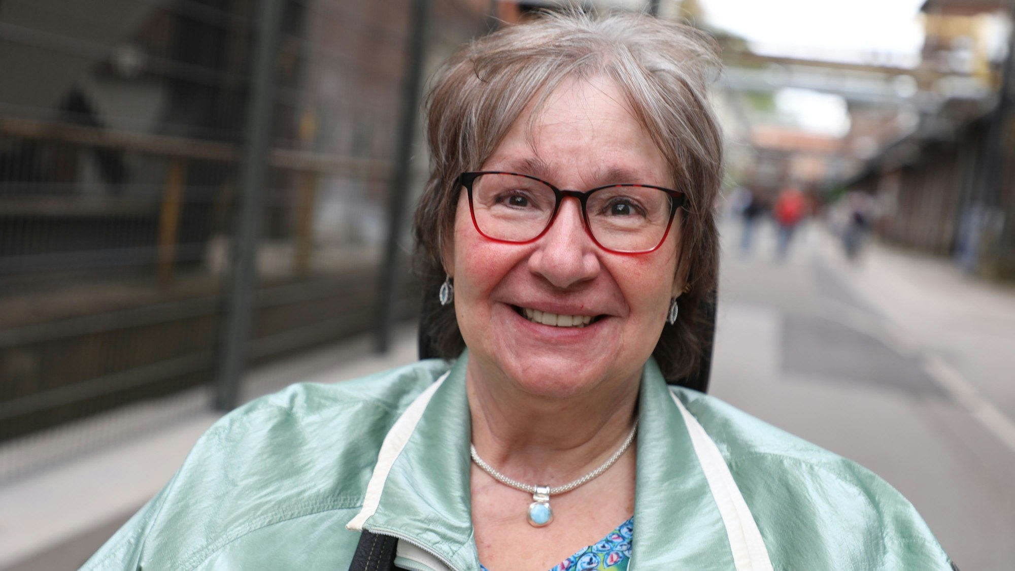 Die ehemalige Zanders-Anwohnerin Monika Krämer sitzt im Rollstuhl in der Mainstreet des Zanders-Geländes.