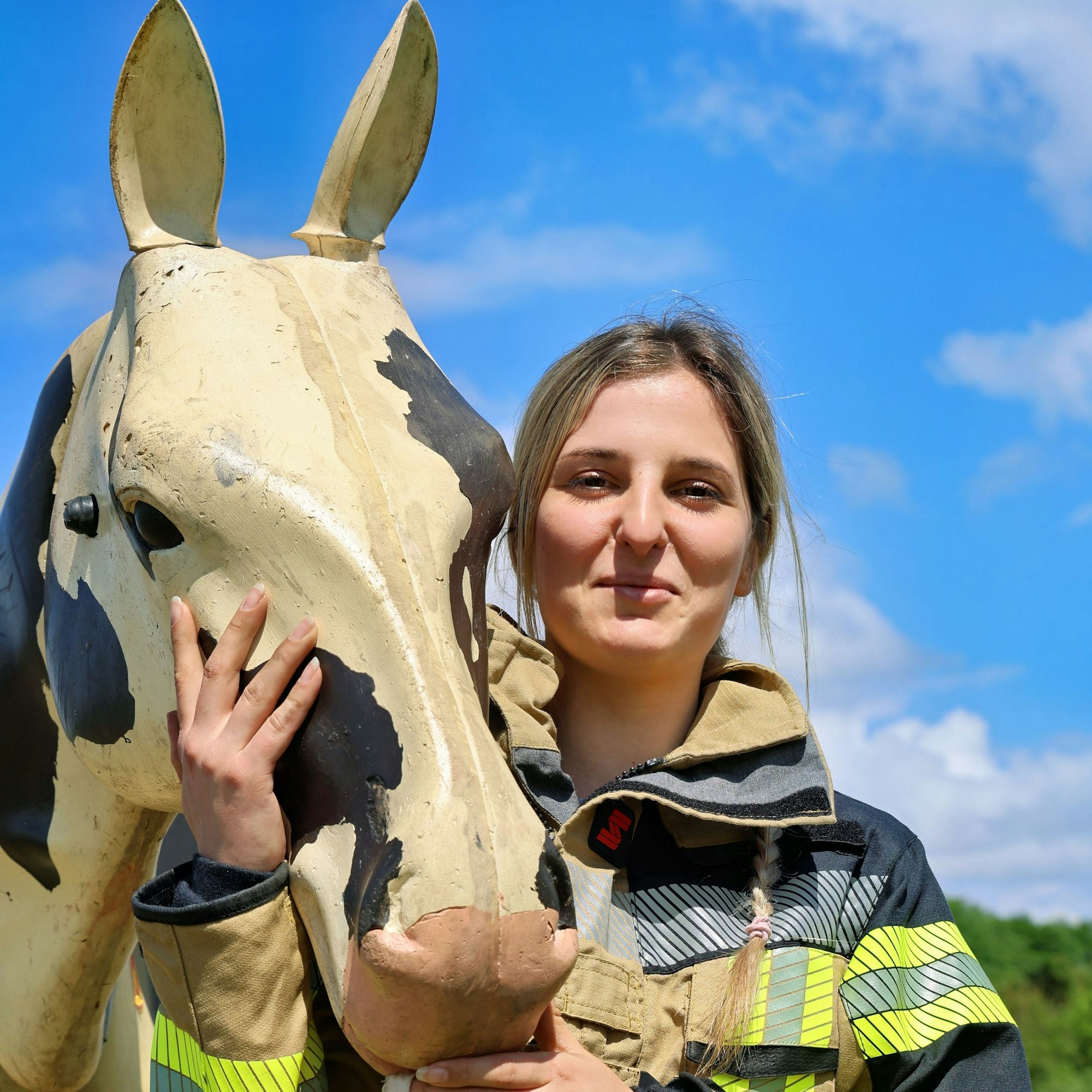 Eine Feuerwehrfrau posiert an „Sams“ Kopf für ein Foto.