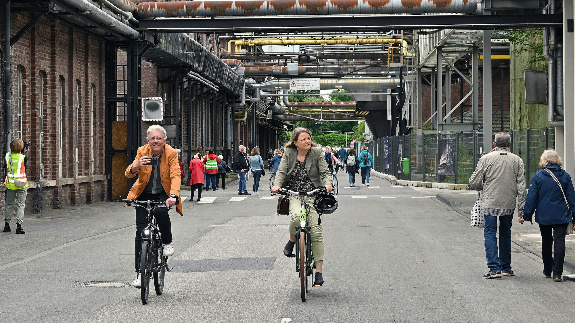 Menschen gehen und radeln über die „Mainstreet“ auf dem Zanders-Gelände in Bergisch Gladbach.