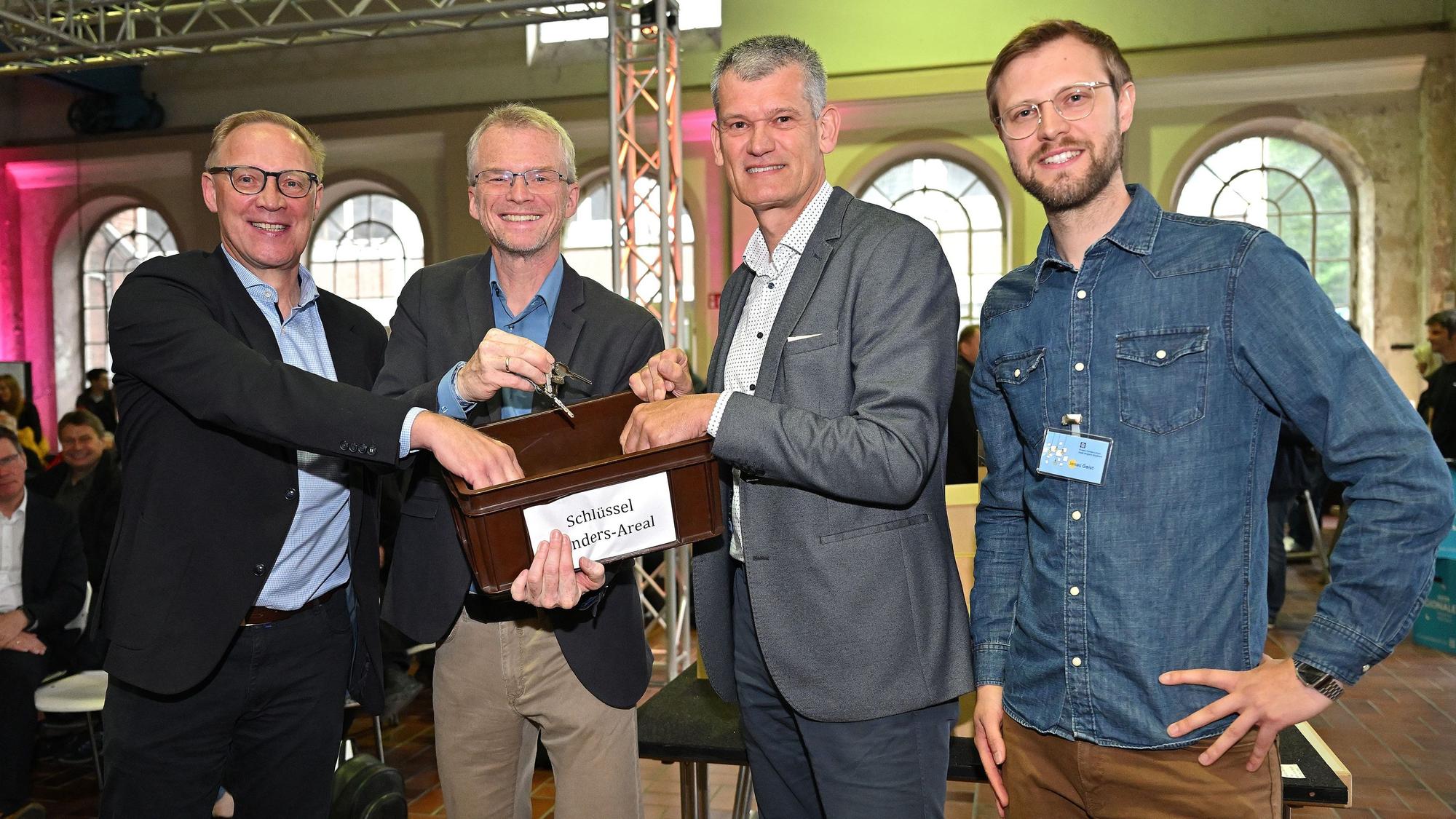 Insolvenzverwalter Dr. Marc d'Avoine übergibt eine Schlüsselkiste an Planer Udo Krause, Bürgermeister Frank Stein und Jonas Geist.