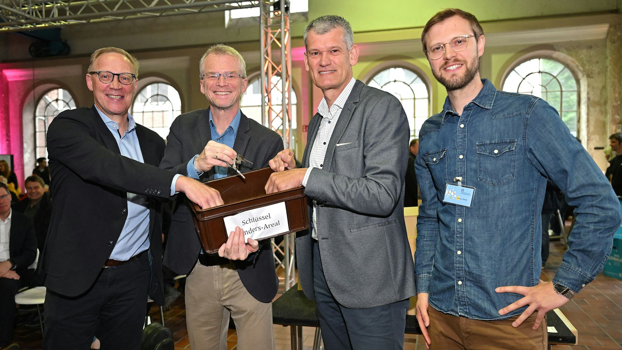 Insolvenzverwalter Dr. Marc d'Avoine übergibt eine Schlüsselkiste an Planer Udo Krause, Bürgermeister Frank Stein und Jonas Geist.