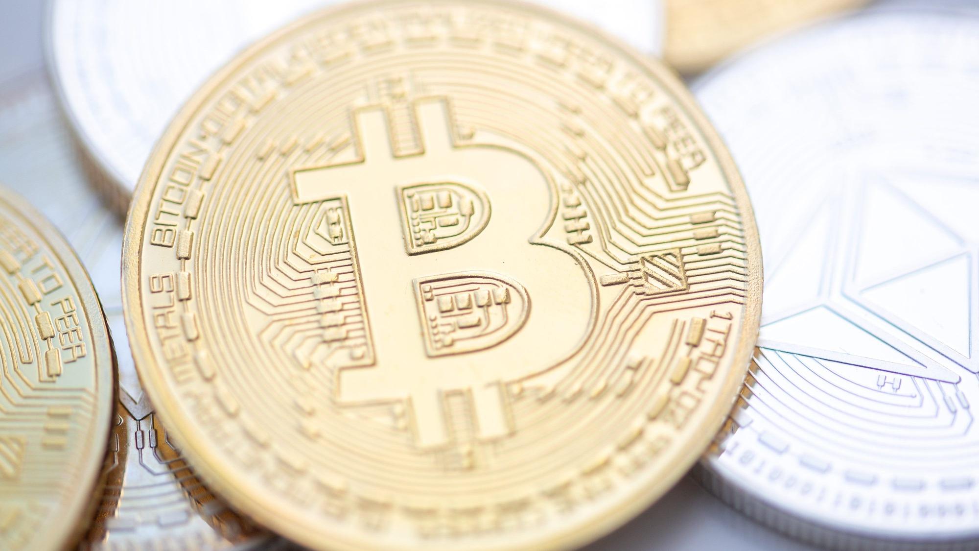 Bitcoin (M) und Ethereum-Münzen sind auf einem Tisch angeordnet.