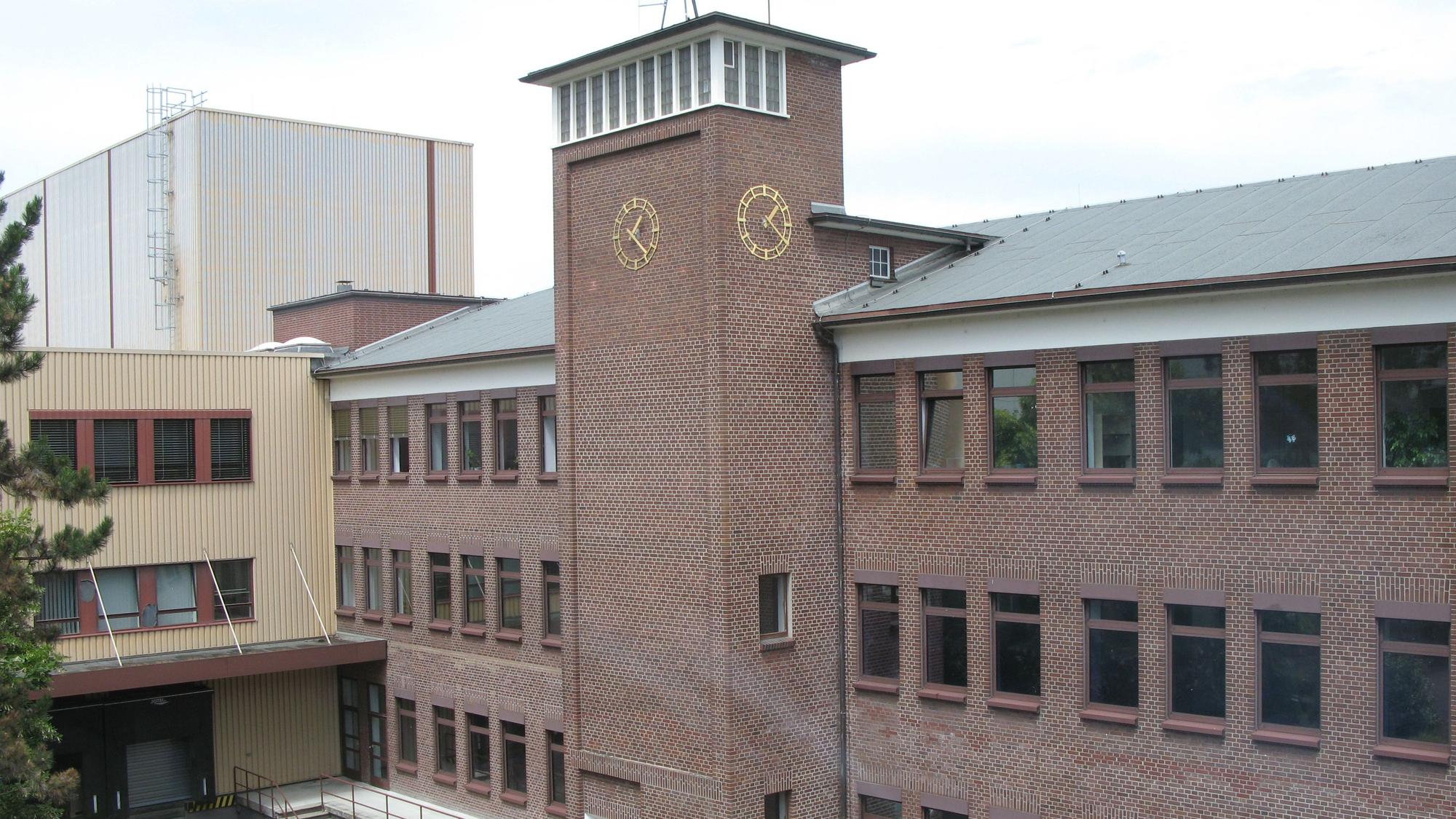 Ein rotes Backsteingebäude mit Turm und Halle.