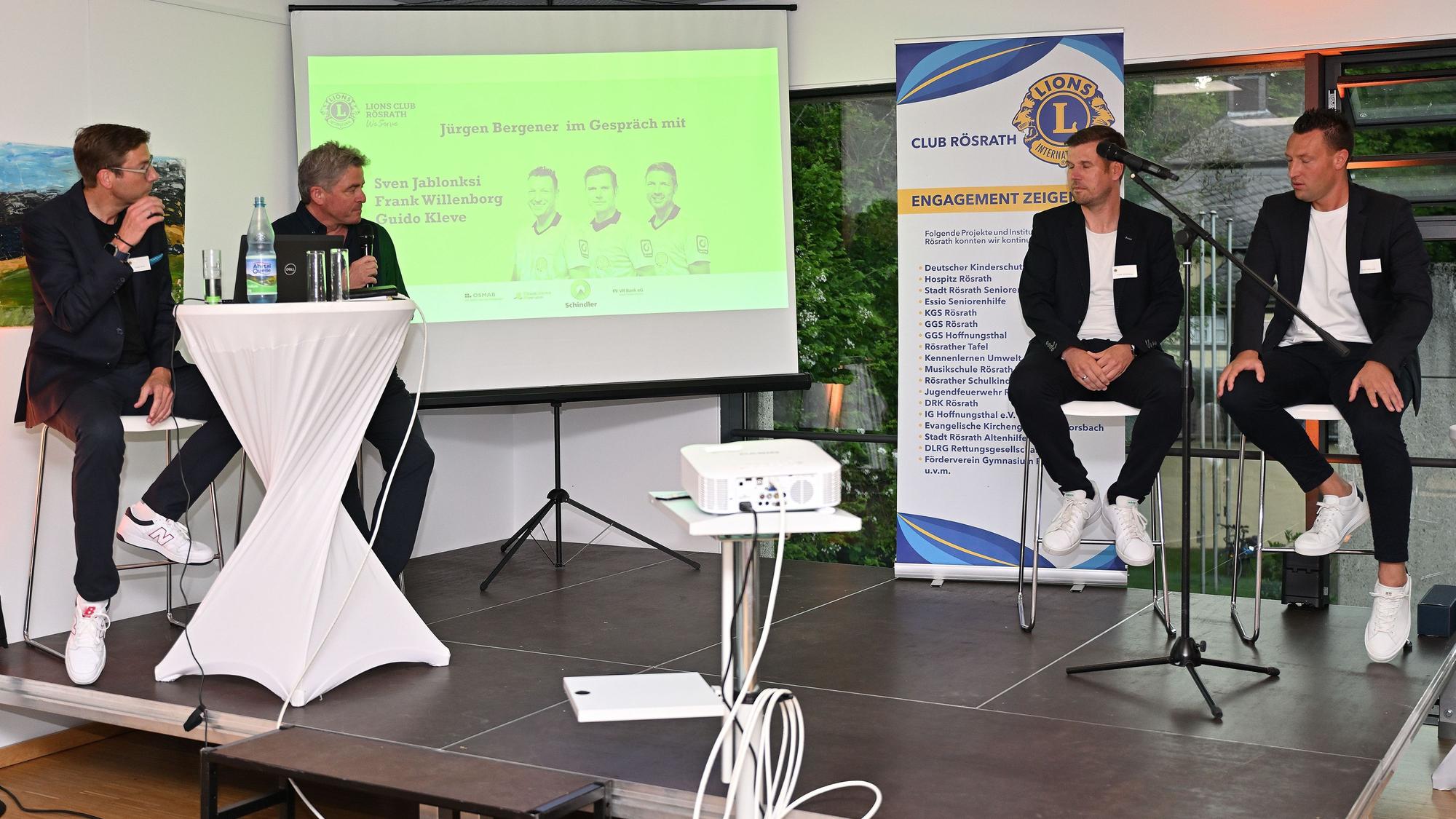 Drei Top-Schiedrichter der UEFA und Bundesliga sind zu Gast bei Lions Rösrath und sitzen auf Barhockern und plaudern..