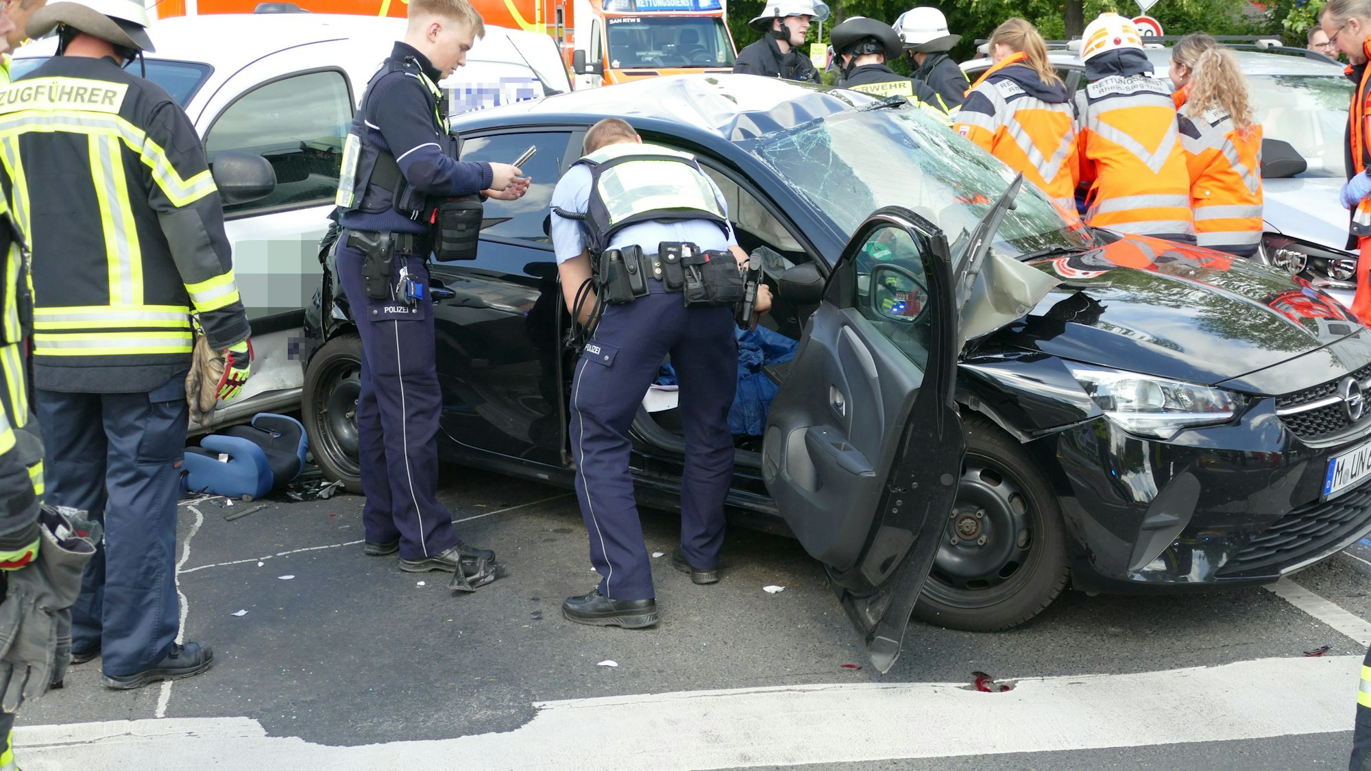 Rettungskräfte befreien den Fahrer eines Autos.