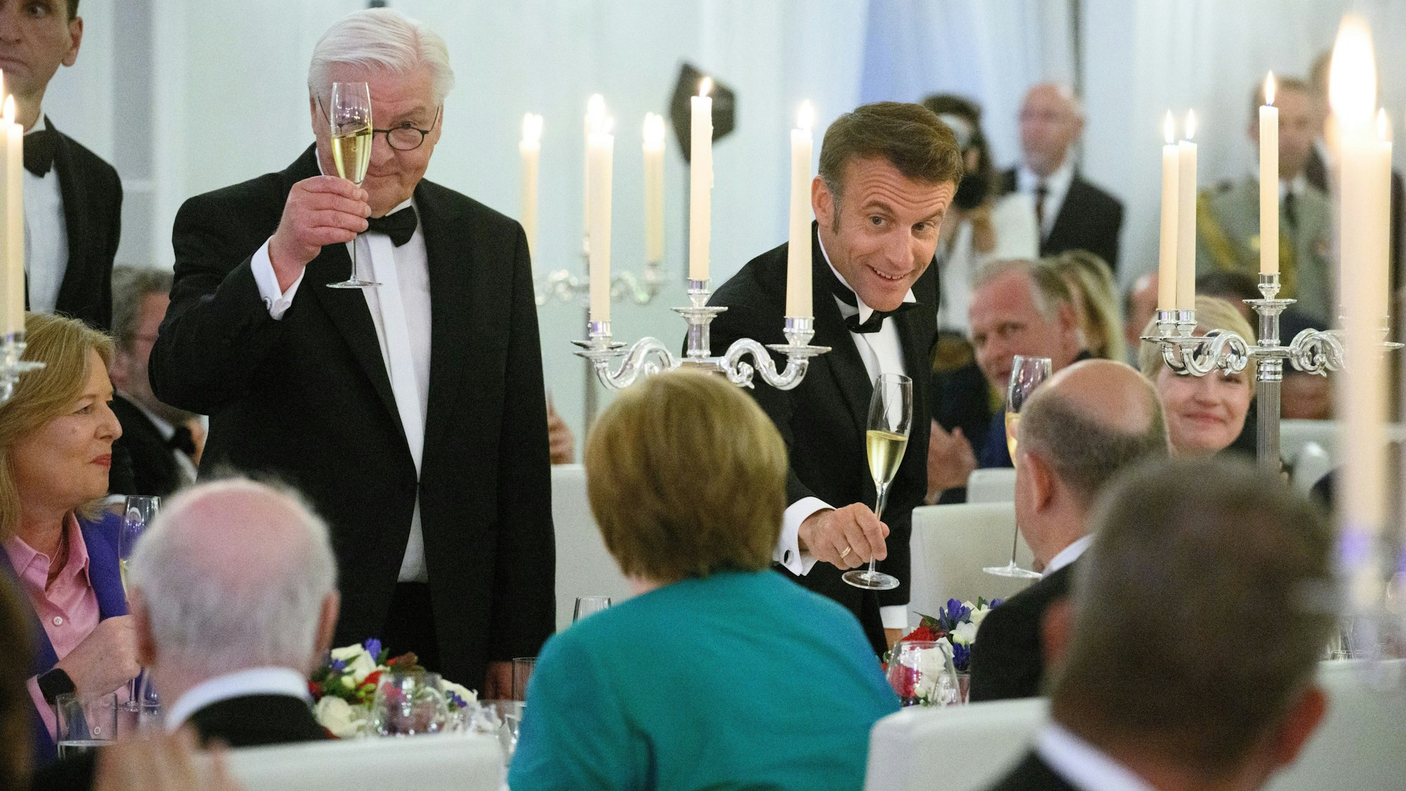 Berlin: Emmanuel Macron, Präsident von Frankreich, und Bundespräsident Frank-Walter Steinmeier (l) stoßen beim Staatsbankett zu Ehren des Präsidenten von Frankreich, Macron, und seiner Frau im Schloss Bellevue mit Bundeskanzler Angela Merkel (CDU), Bundeskanzlerin a.D., und Olaf Scholz (SPD) an.