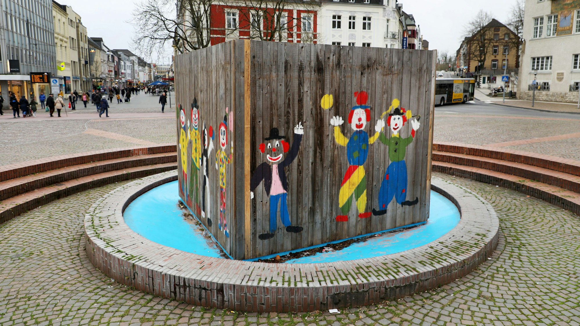 Auf dem Konrad-Adenauer-Platz in Bergisch Gladbach ist der Brunnen mit einer Clown-Abdeckung verschalt.