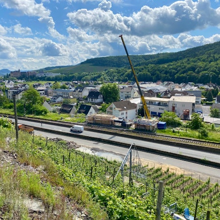 Über dem Ahrtal hebt der Kran das erste Bauteil des alten Walporzheimer Bahnhofs an.