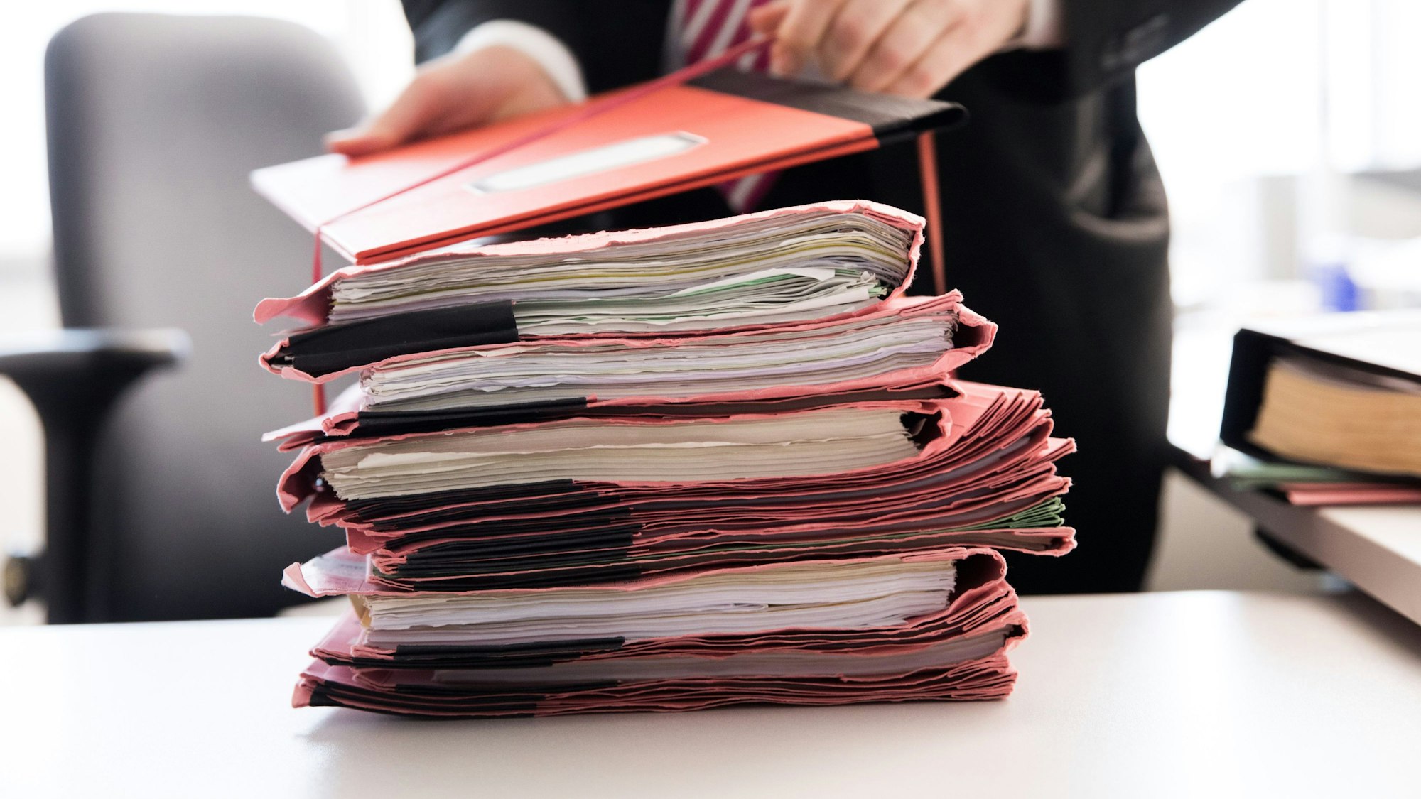 Ein Oberstaatsanwalt bindet einen Stapel Gerichtsakten. (Symbolbild)