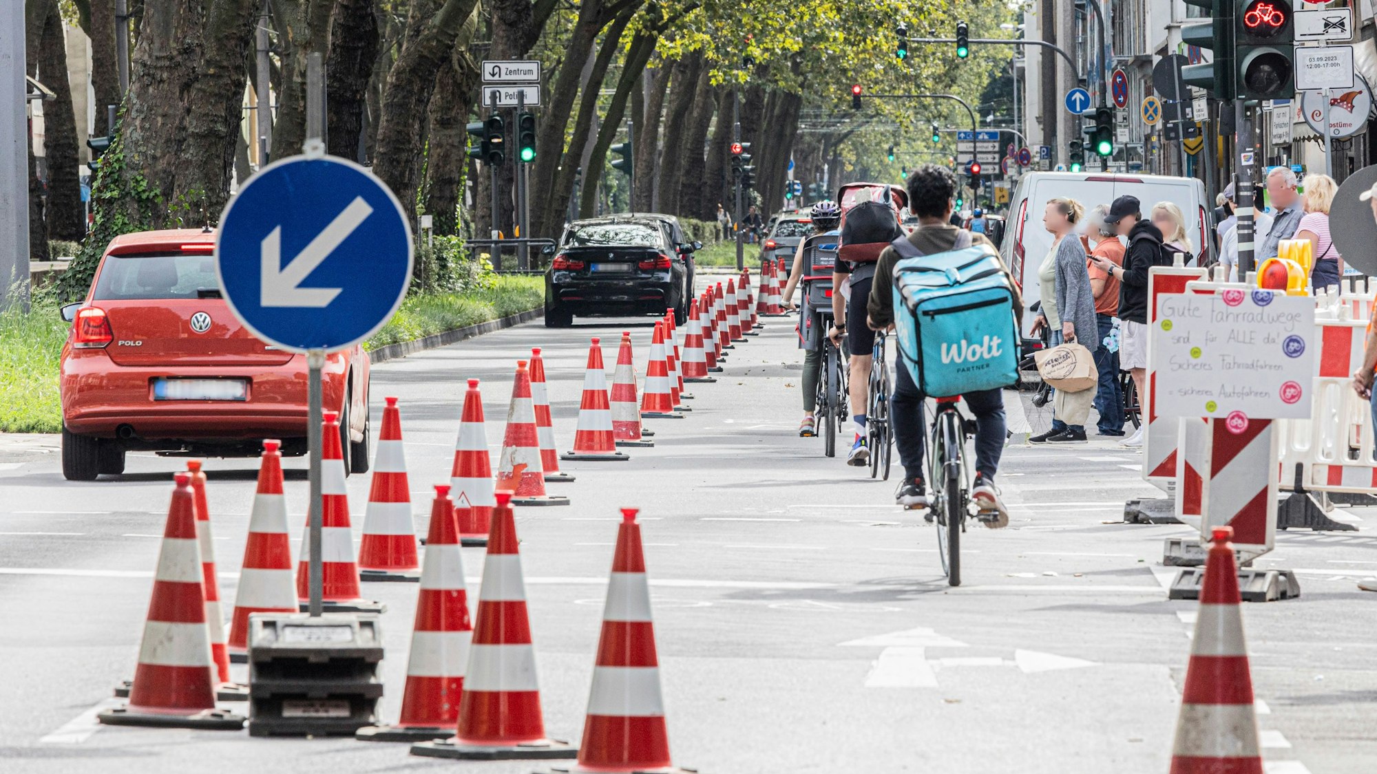 Eine Radspur ist auf der Luxemburger Straße mit Pylonen abgetrennt. Links fahren die Autos, rechts die Radfahrenden.