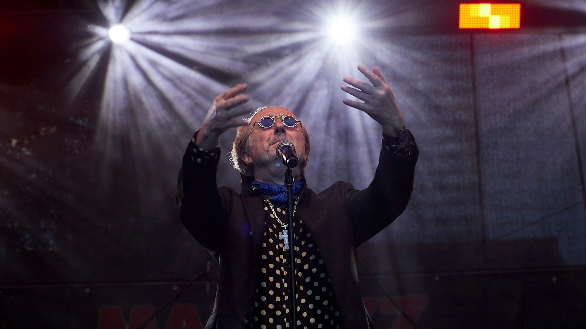 Peter Zahn singt, er trägt eine runde Sonnenbrille.