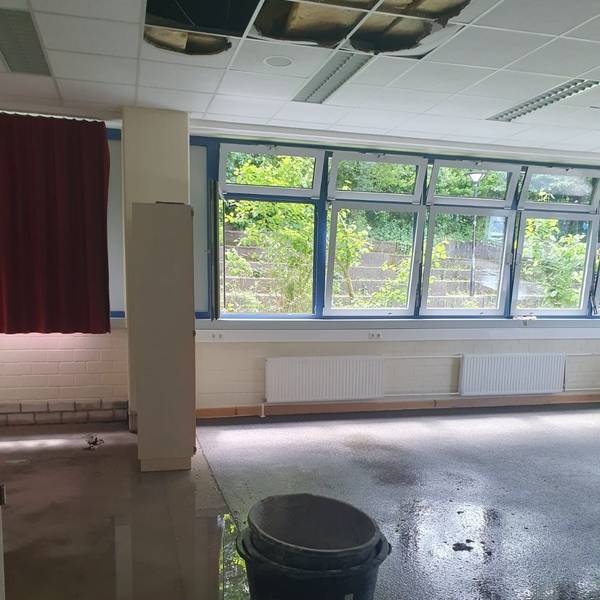 Ineinander gestapelte Eimer stehen auf dem noch nassen Boden.