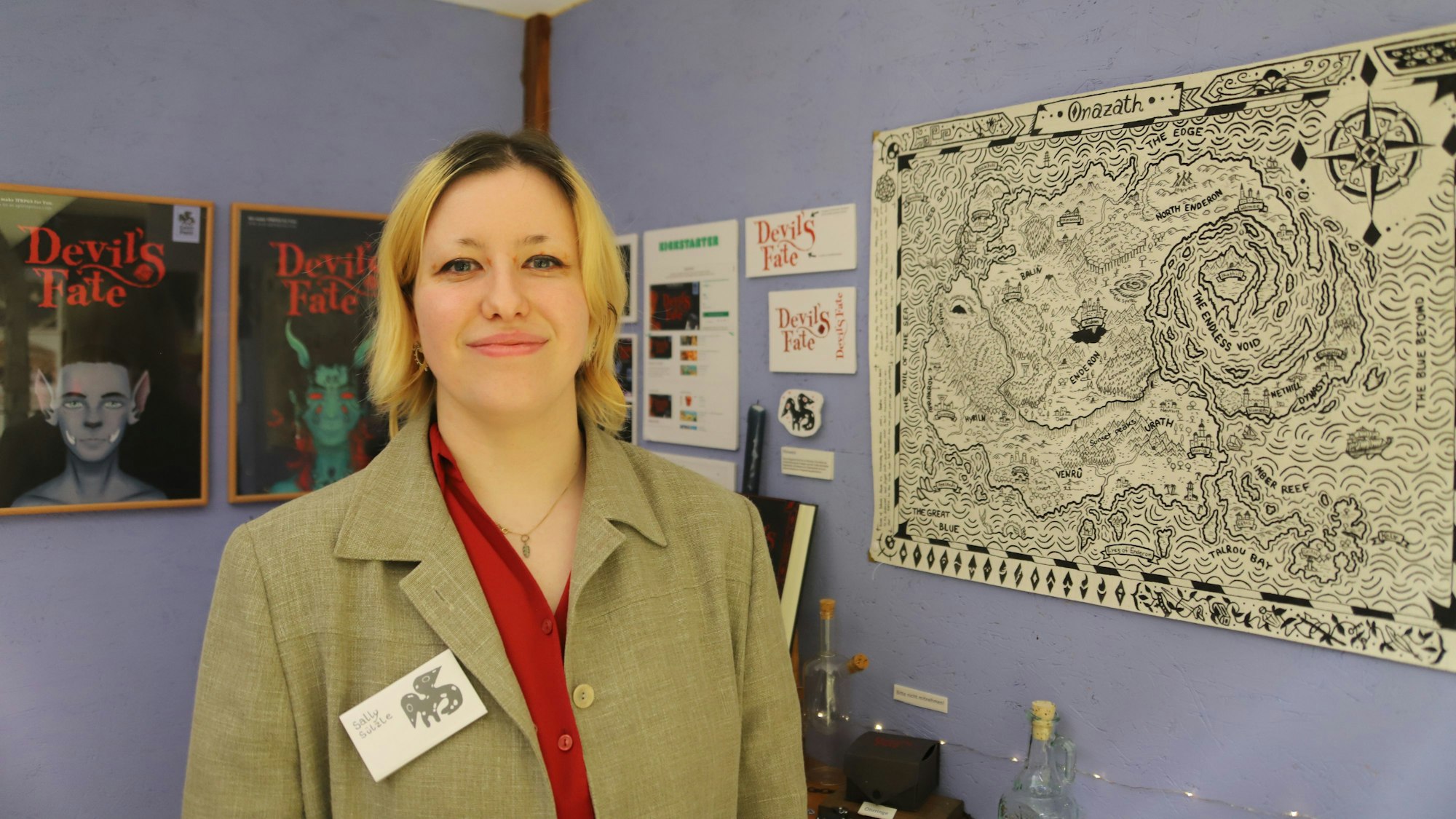 Sally Sützle steht neben einer Karte, die sie von Hand gezeichnet hat.