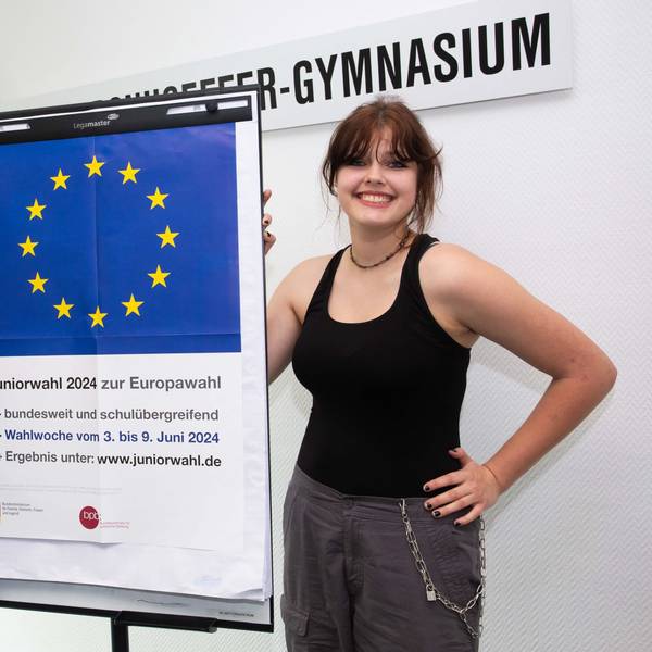 Zwei Schülerinnen vor einem Plakat.