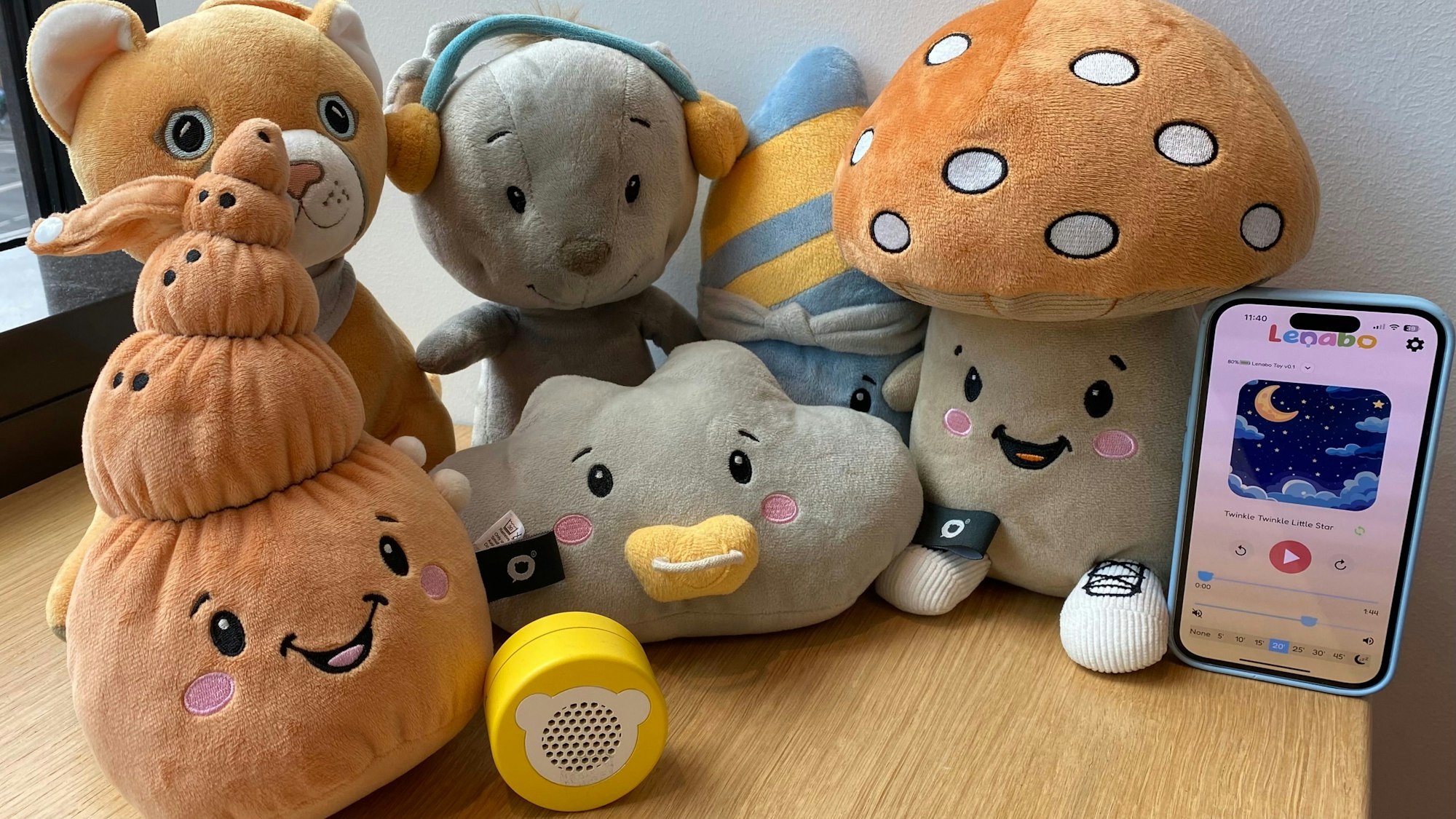 Die Plüschtiere von der Bornheimer Firma Lenabo, der Smart Speaker in Gelb und die App auf dem Smartphone.