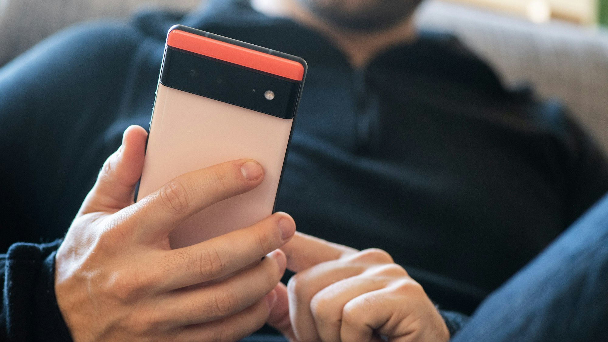 Ein Mann hält ein Handy in seinen Händen.