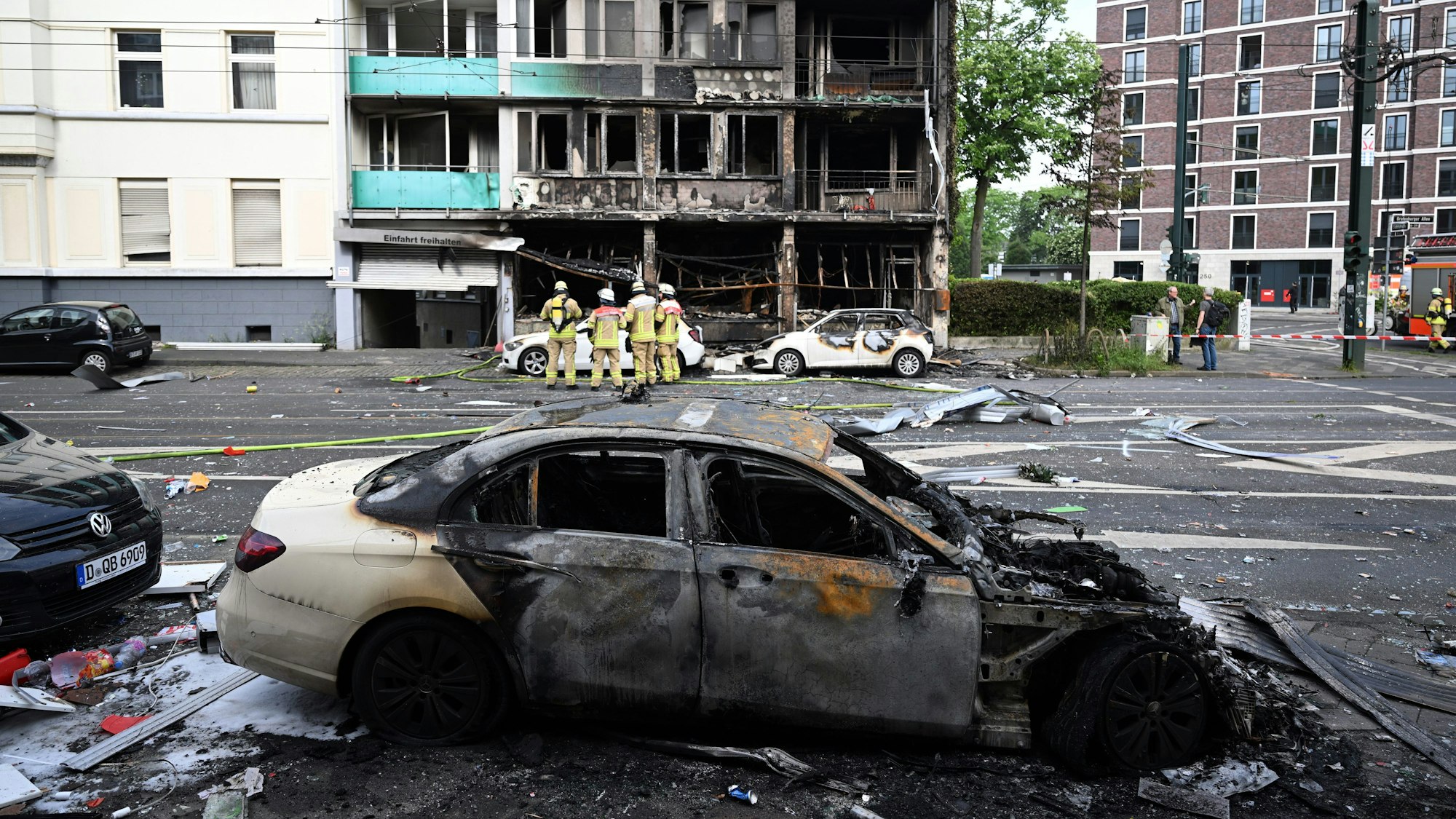 Feuerwehrleute stehen vor einem Wohnhaus, in dem ein Brand wütete.