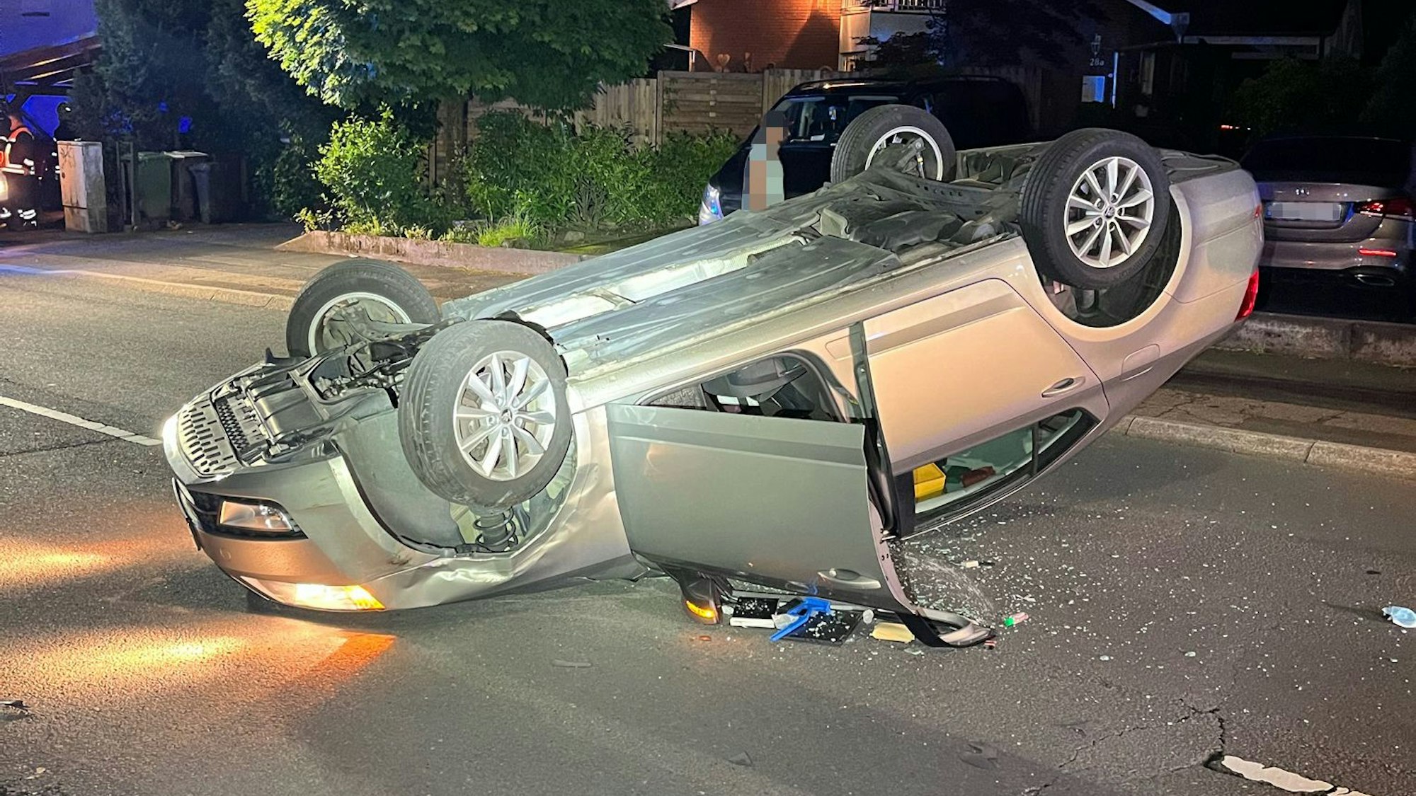 Ein Pkw Skoda liegt auf dem Dach auf der Straße Am Sommerberg in Rösrath-Forsbach.