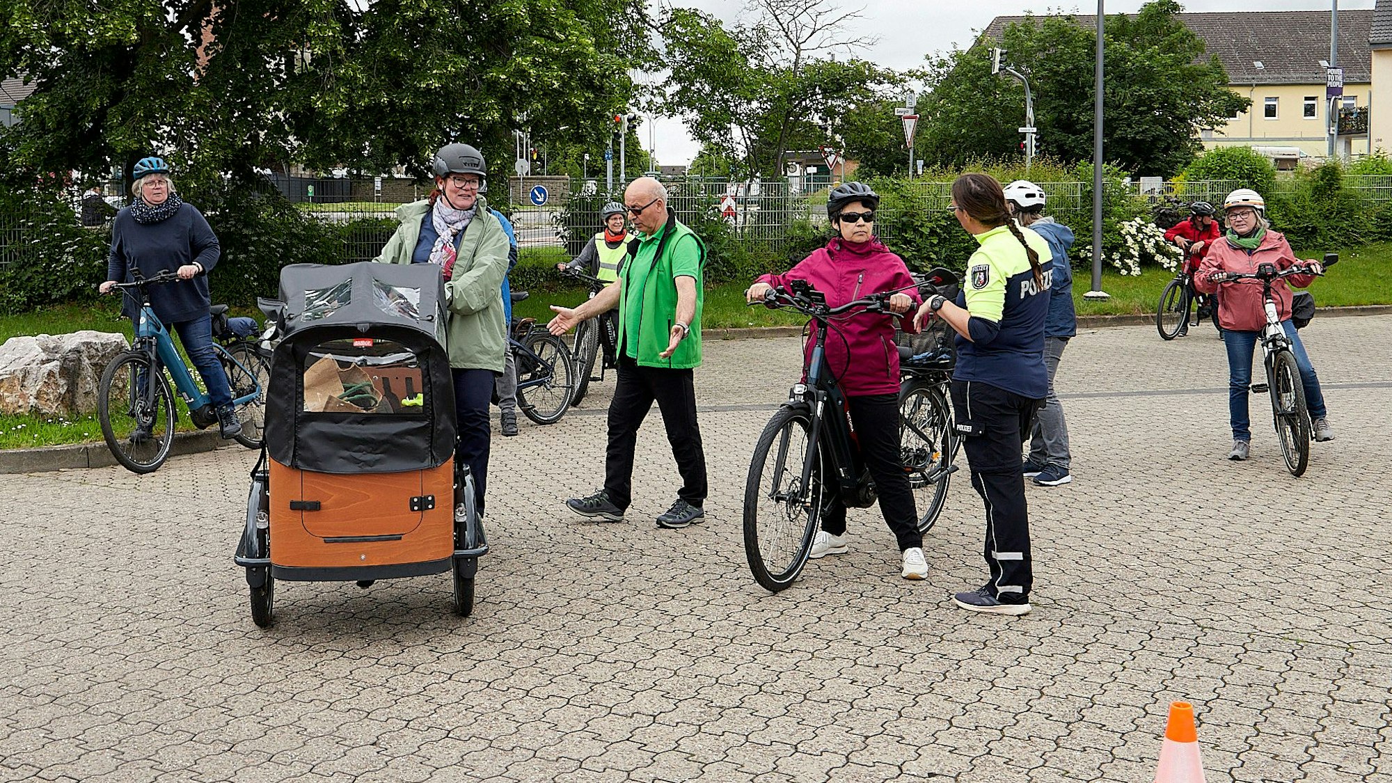 Eine Gruppe von E-Bike-Fahrern folgt den Ausführungen einer Polizeibeamtin.