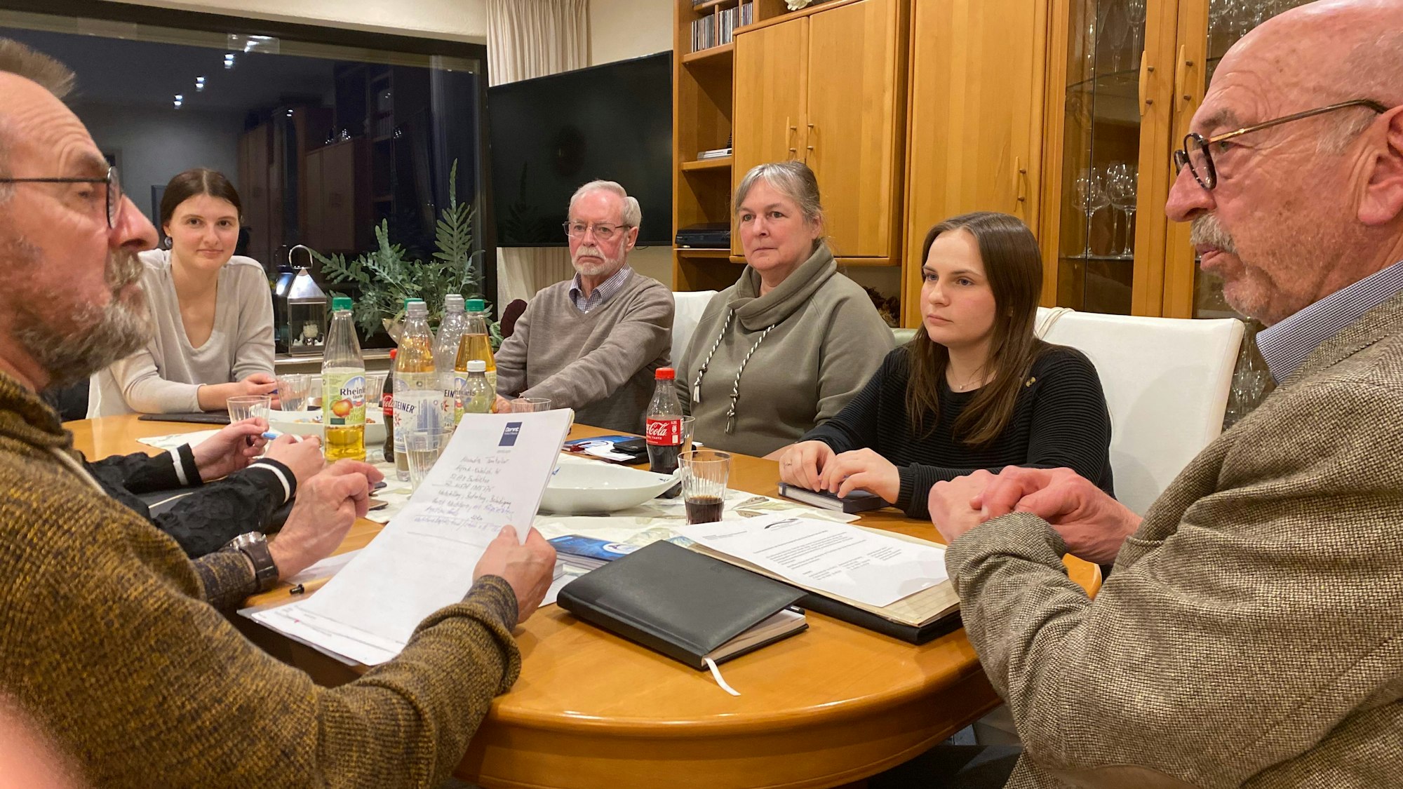 Um einem Holztisch sitzen die Teammitglieder des Weißen Rings: Yasmin Fuhl, Friedrich Ohst, Rudi Esch, Anja Blum, Ann Kathrin Buchau, Franz Buchau