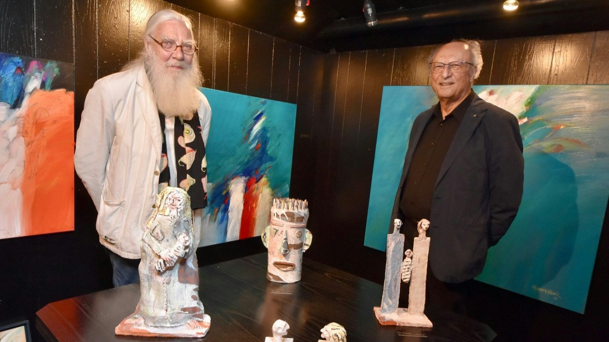 Werner Reuber hinter seinen Skulpturen, Mehmet Güler vor seinen Gemälden.