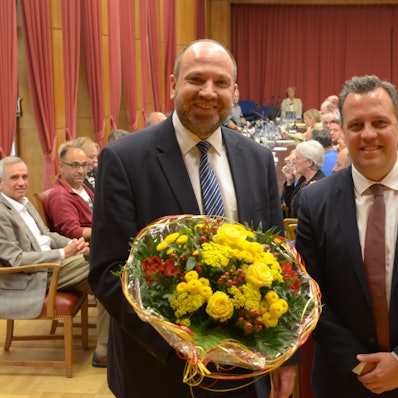 René Strotkötter (l.) und Sacha Reichelt stehen nebeneinander im Ratssaal, hinter ihnen sitzen Stadtverordnete an ihren Tischen.