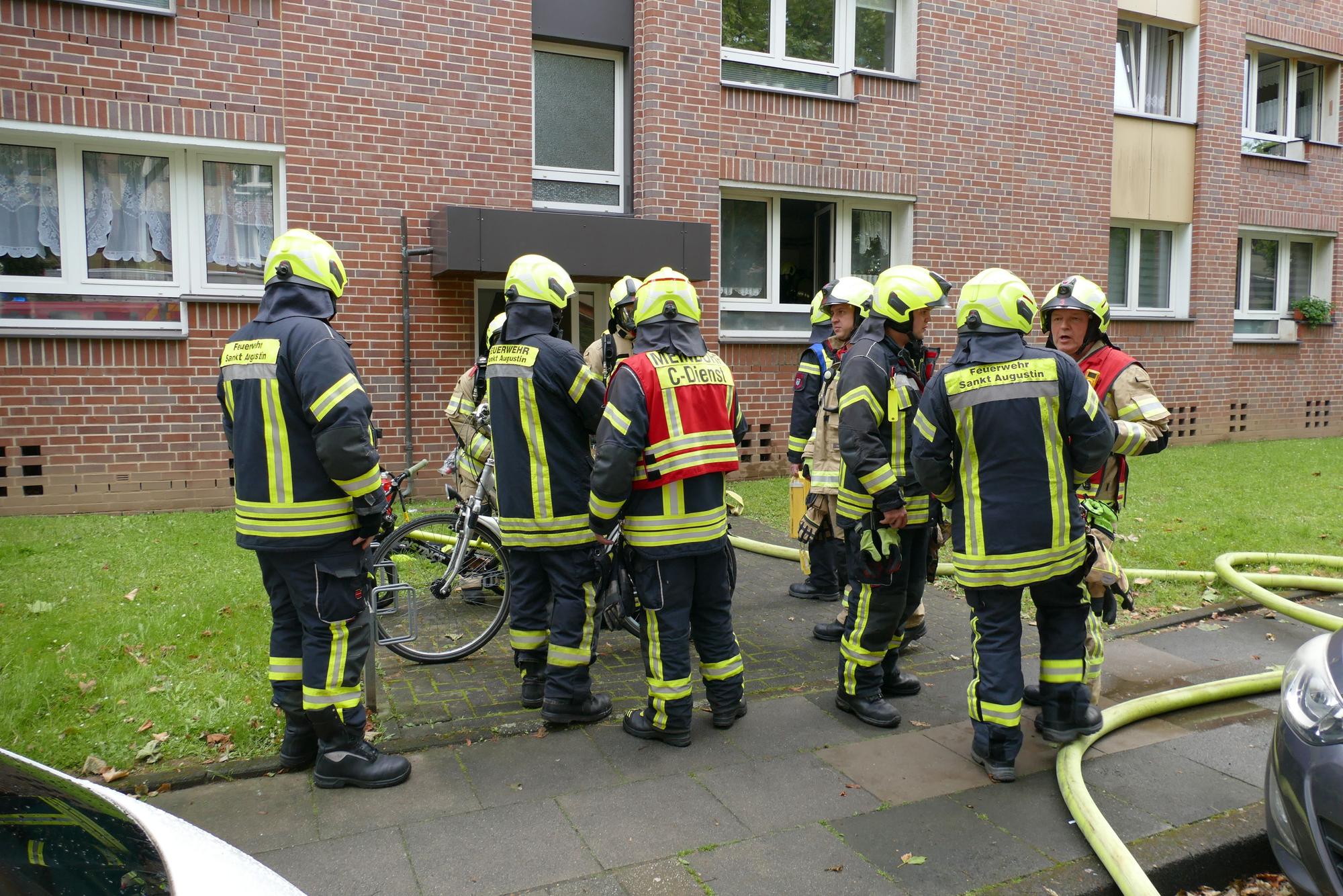 Feuerwehrleute stehen vor dem betroffenen Haus.