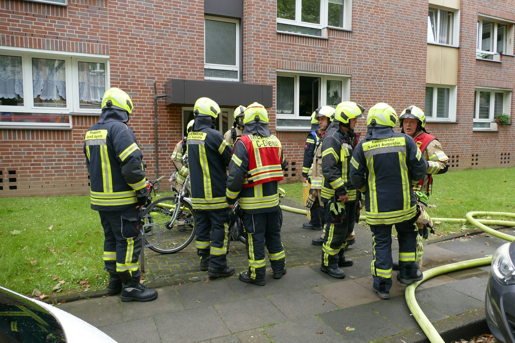 Feuerwehrleute stehen vor dem betroffenen Haus.