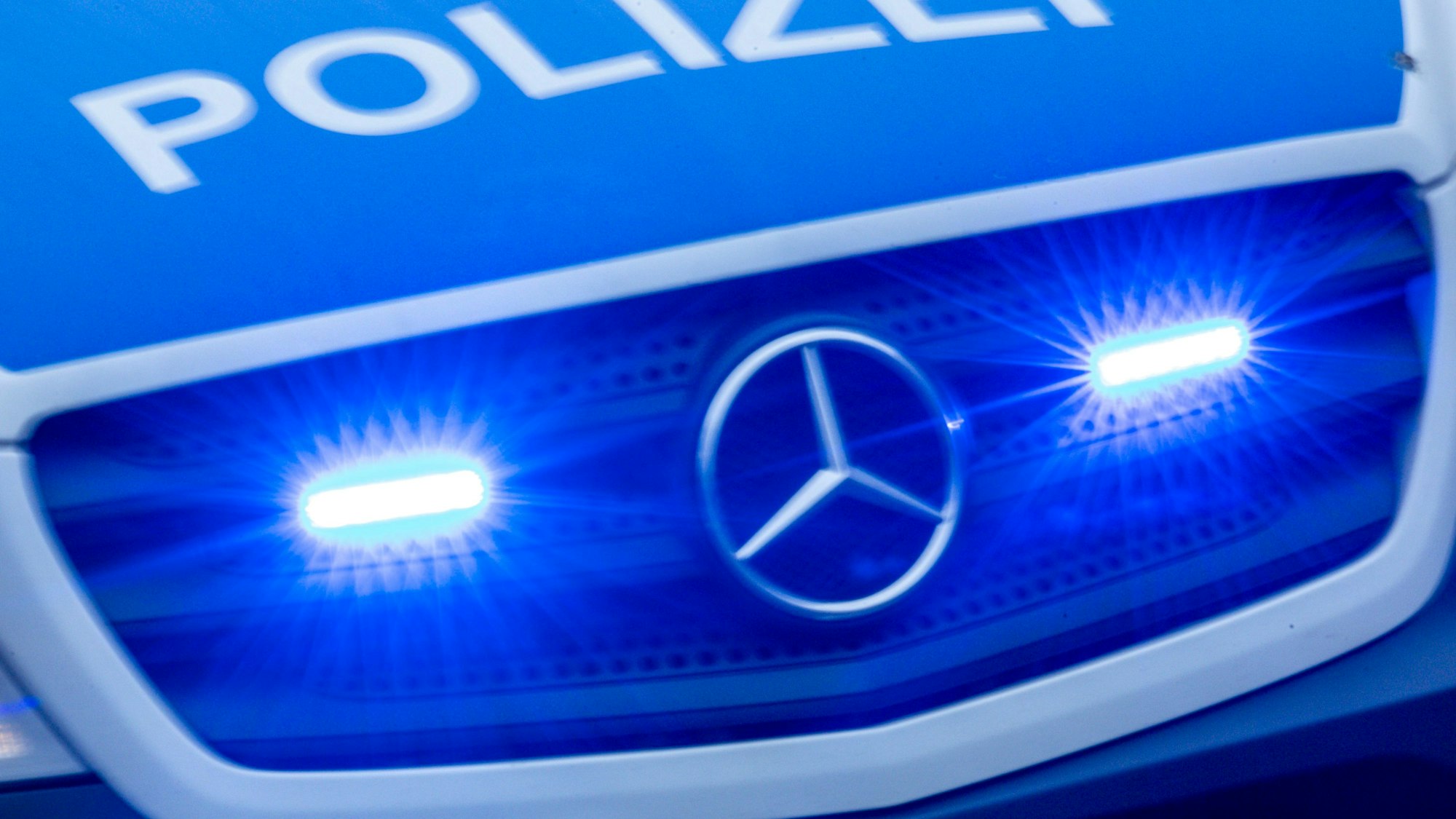 Ein Einsatzfahrzeug der Polizei fährt mit Blaulicht durch die Innenstadt.