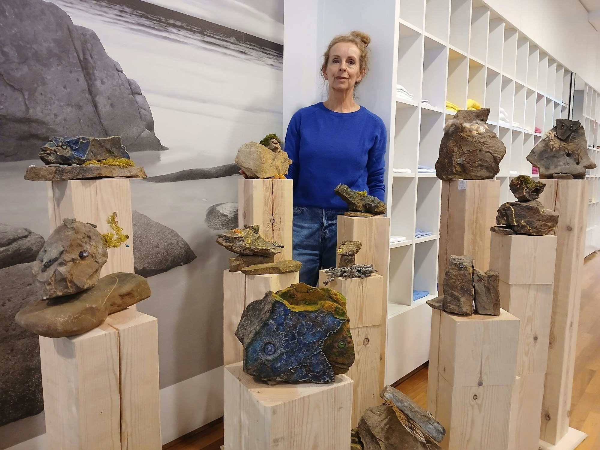 Eine Frau mit Steinplastiken auf Holzstelen