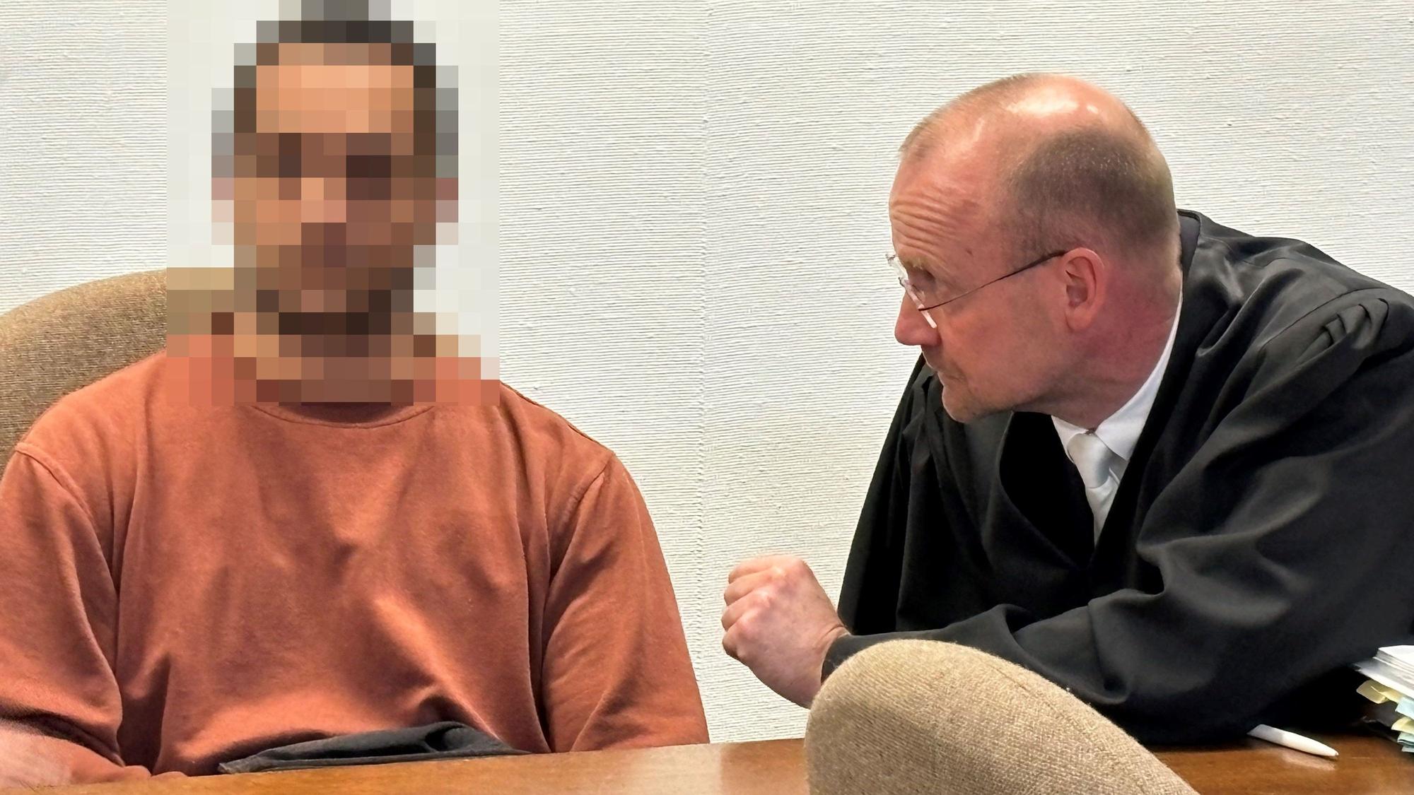Der angeklagte Vater sitzt neben seinem Verteidiger im Saal des Landgerichts.