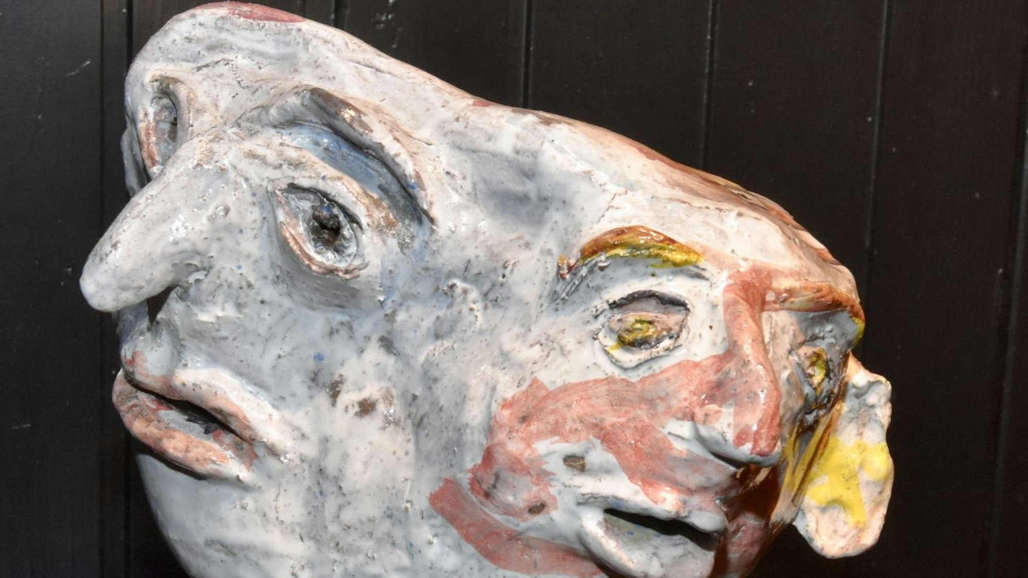 Eine Terracotta-Skulptur, die zwei miteinander verbundene Köpfe zeigt.