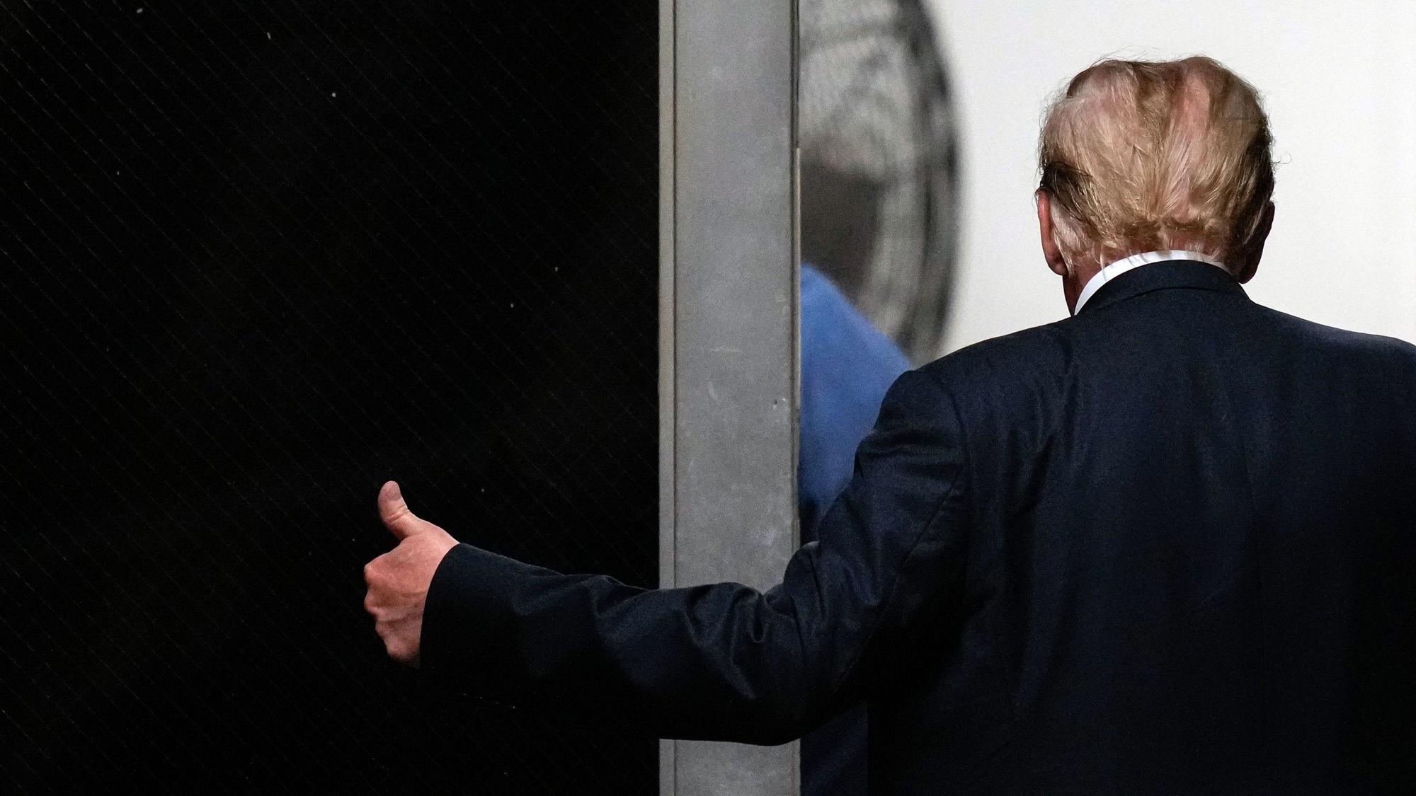 Der Ex-Präsident der USA, Donald Trump, ist von hinten zu sehen und gibt einen Daumen hoch.