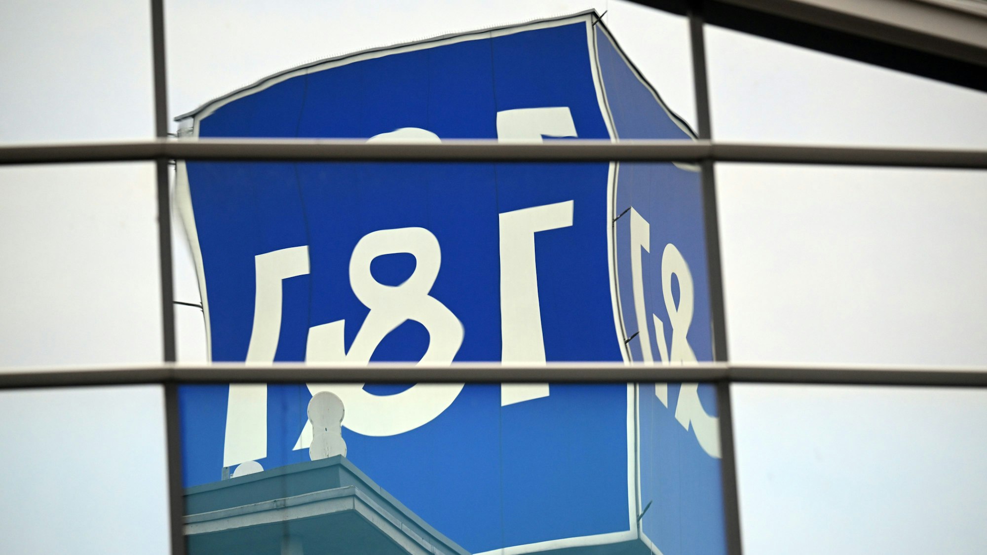 In der Reflexion von Glasscheiben wird das Logo des Mobilfunkanbieters 1&1 verzerrt. (Archivbild)