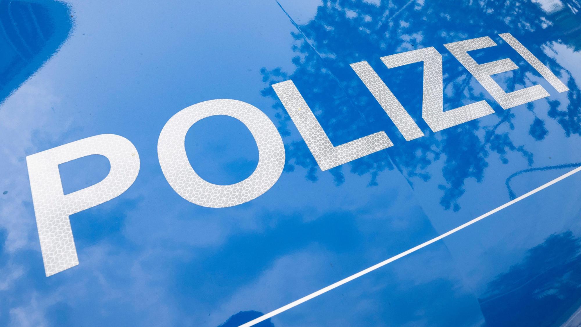 Der Schriftzug „Polizei“ ist auf einem Streifenwagen zu lesen.