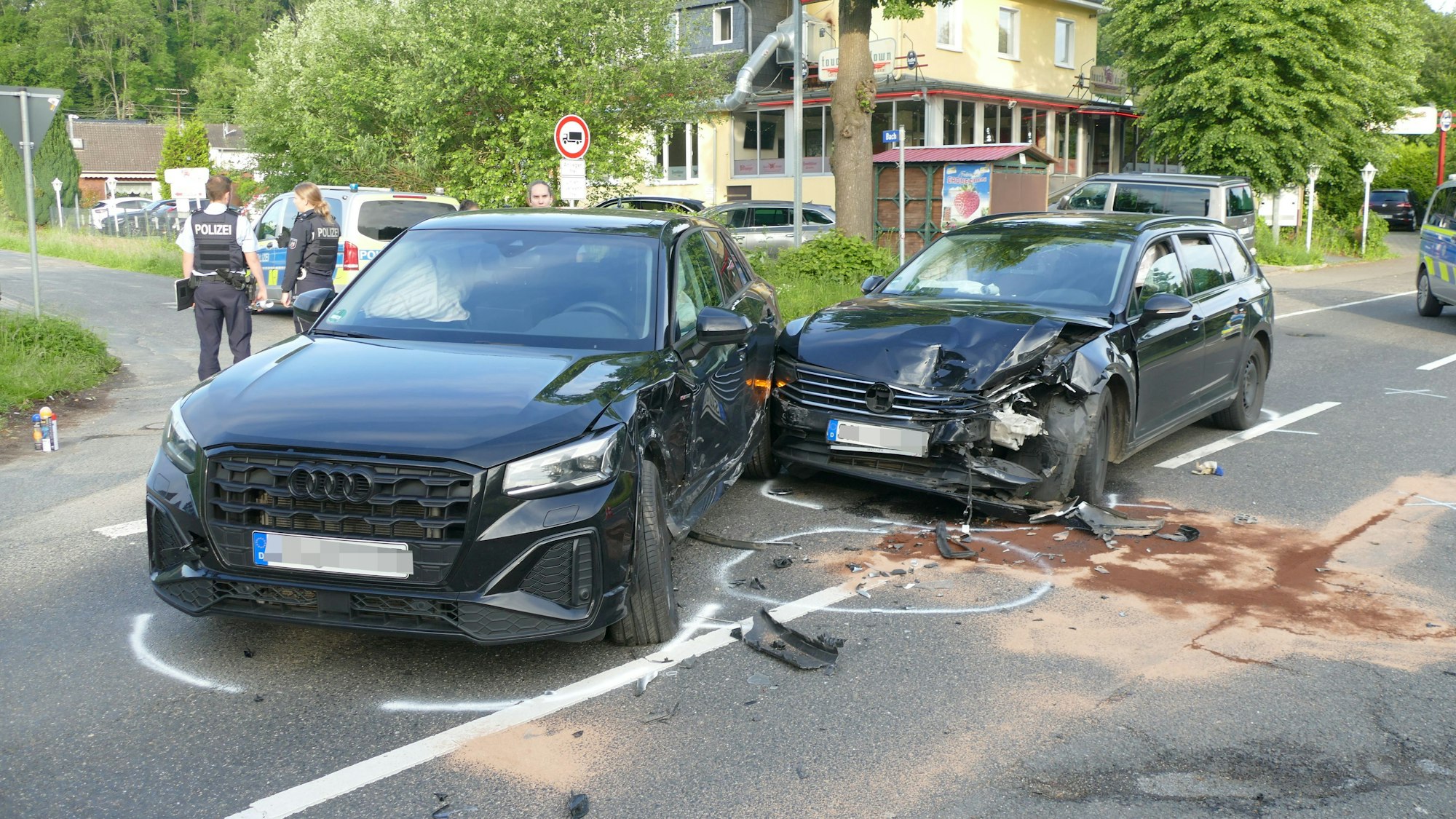 Zwei beschädigte Autos stehen auf einer Straße.