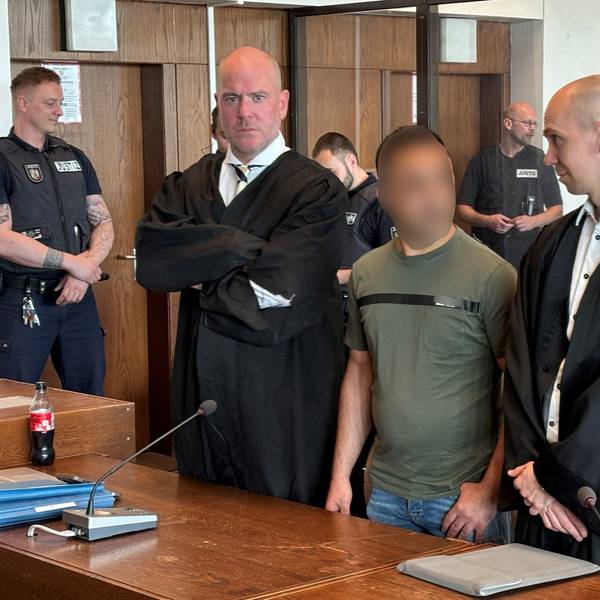 Ein Angeklagter steht zwischen seinen Anwälten vor dem Kölner Landgericht.