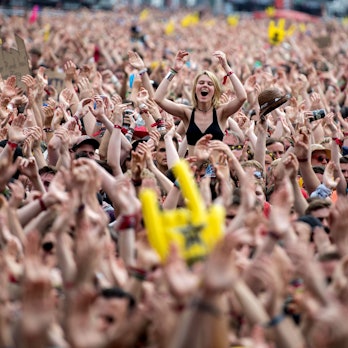 Das Bild zeigt die Menschenmenge vor der Hauptbühne. Eine Frau ragt aus der Masse an nach oben gehaltenen Armen hervor.