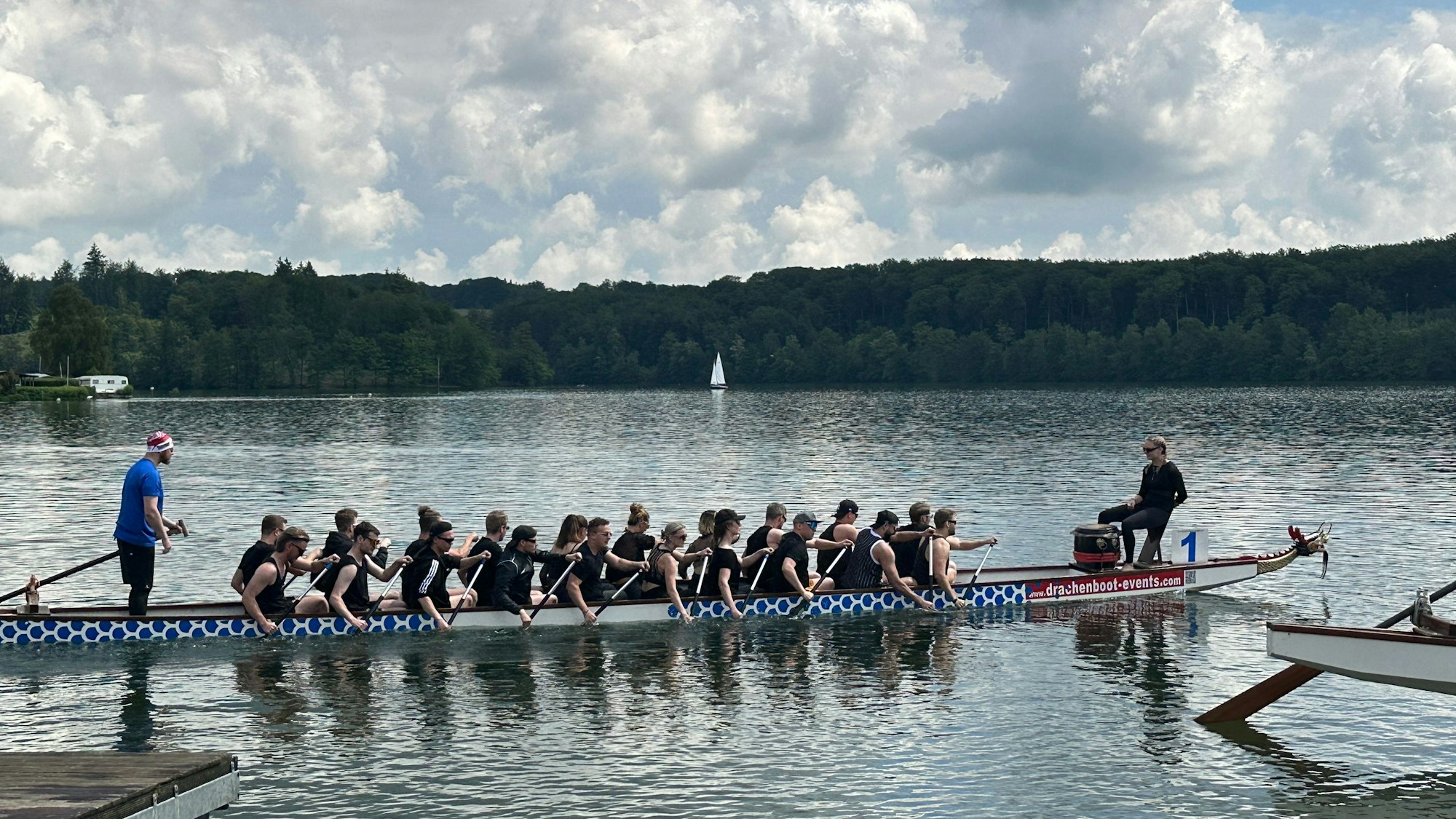 20 Ruderer, ein Trommler und ein Steuermann bilden das Team in einem Drachenboot.