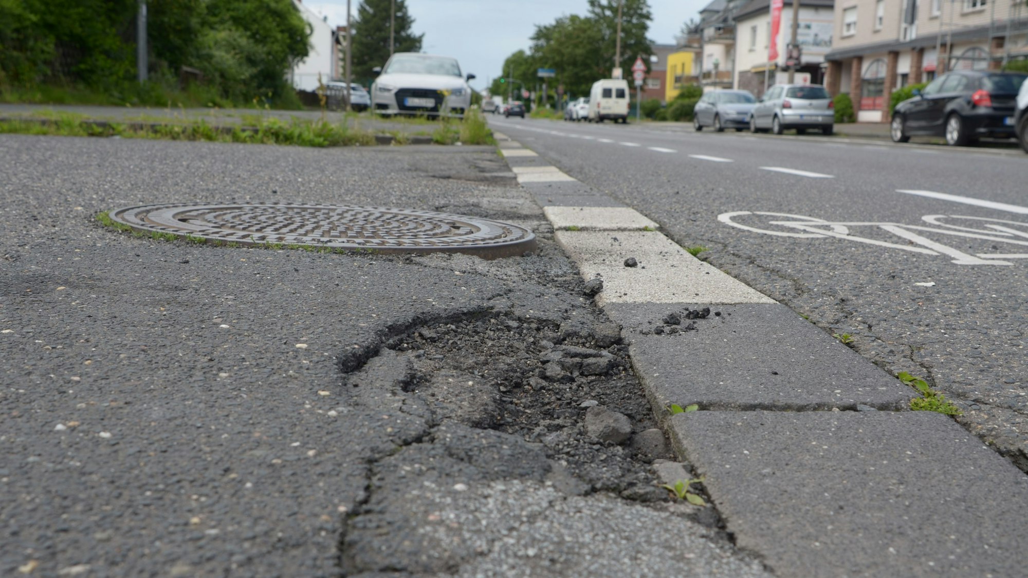 Der Asphalt weist Löcher und Risse auf.