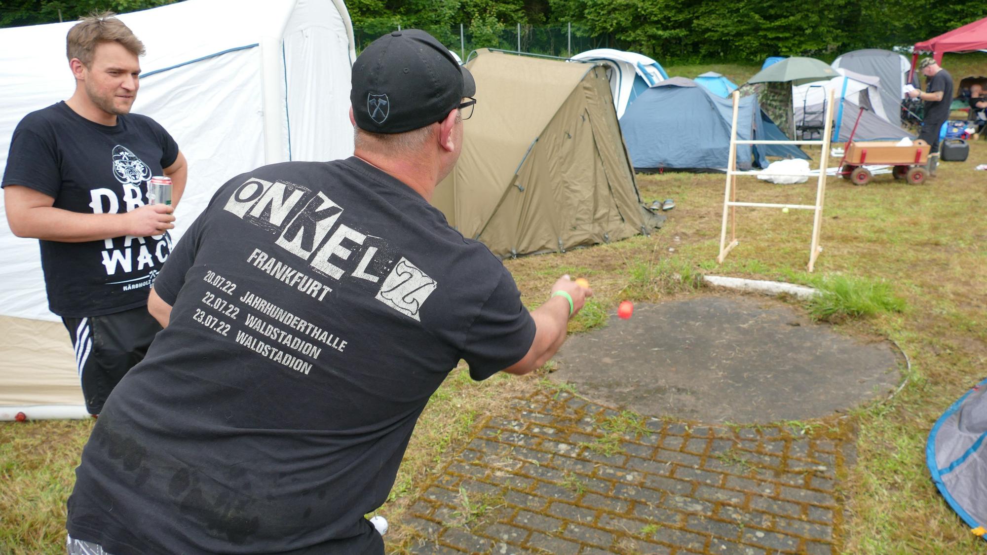 Ein Mann wirft einen Ball in Richtung einer Leiter.