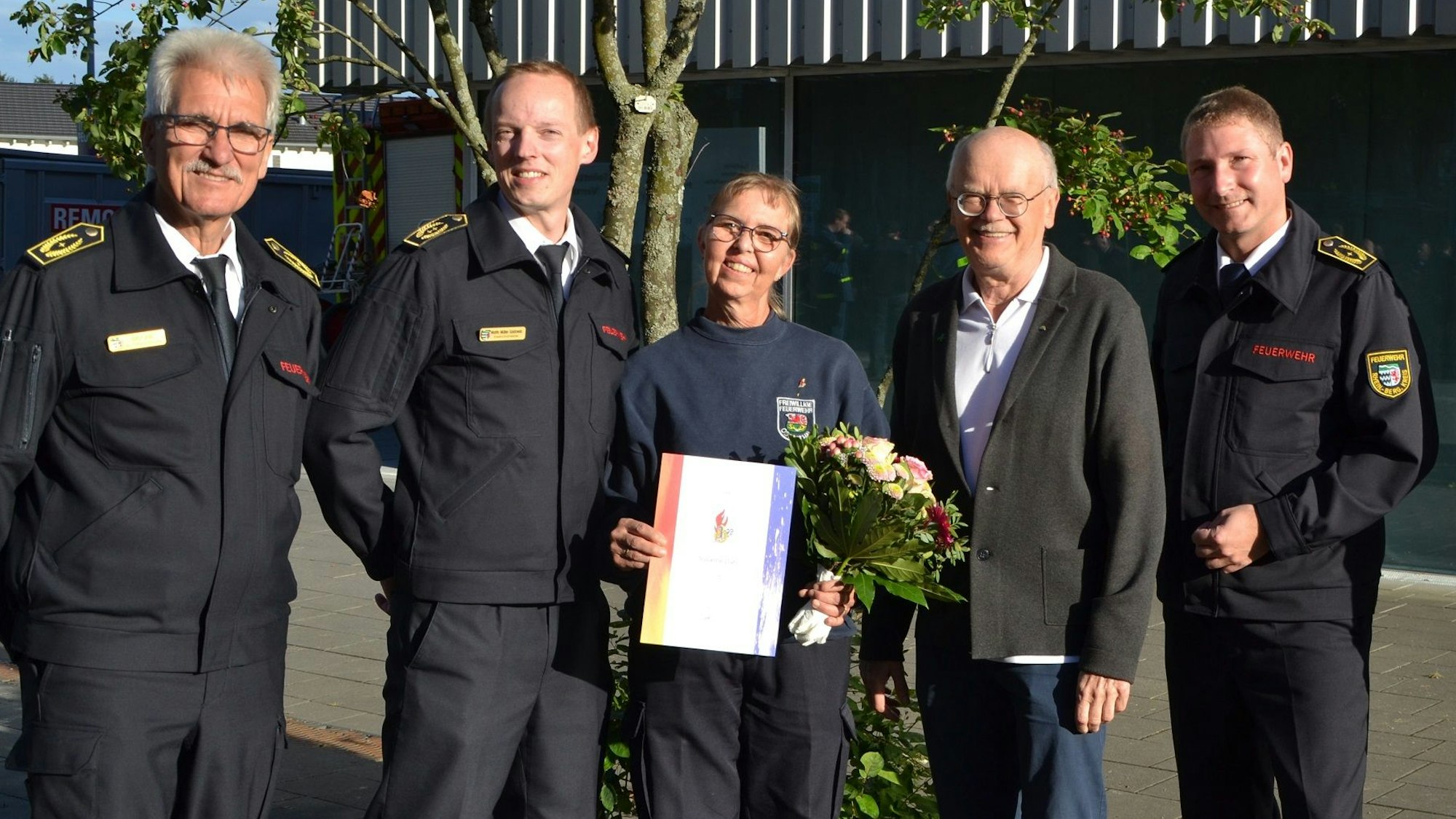Fünf Menschen stehen beim Kreisjugendfeuerwehrzeltlager in Leverkusen in der Sonne.