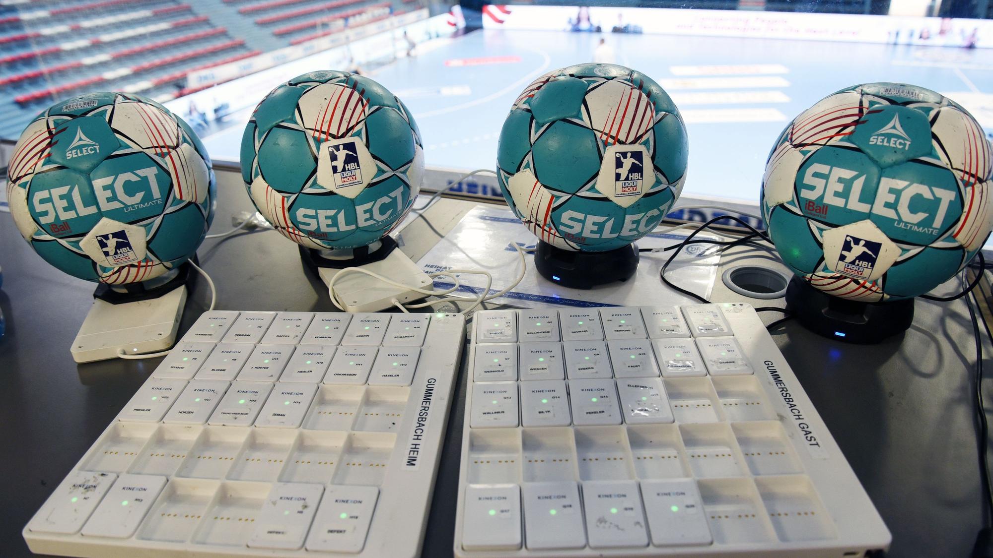 Vier Handball-Spielbälle und ihre Sensoren werden geladen.