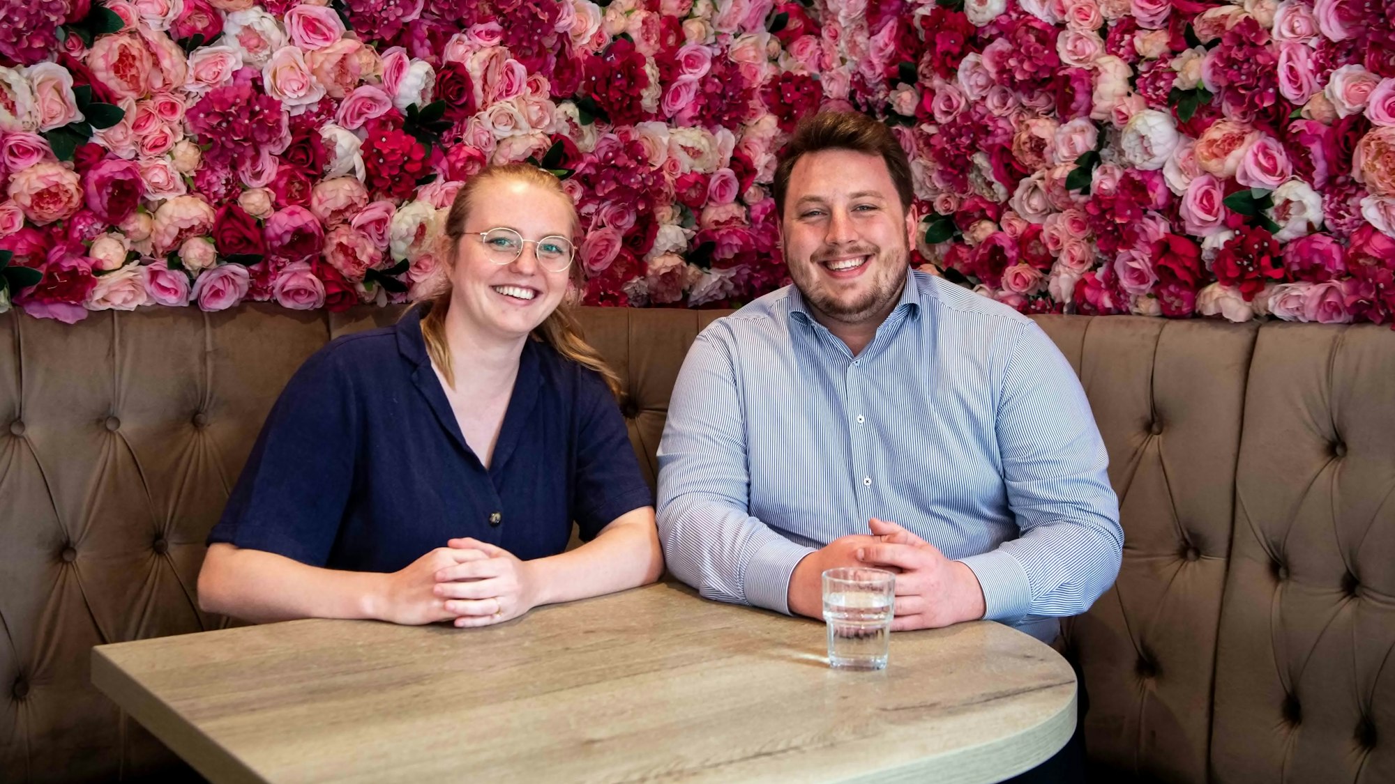 Vincent Lemke und Helena Vitt sitzen auf einer Bank an einem Tisch.