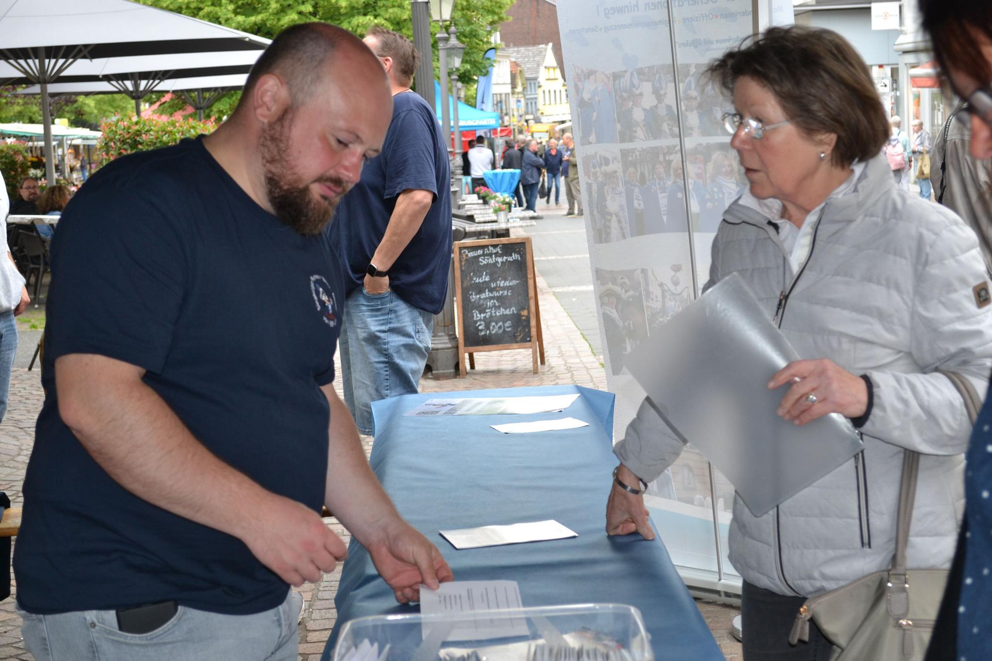 Ein Mann und eine Frau an einem Verkaufsstand.
