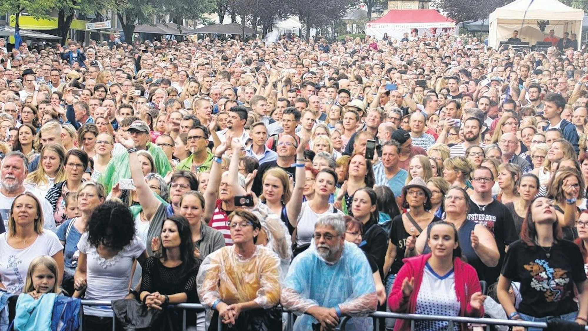 Dicht gedrängt stehende Besucher einer Freiluftveranstaltung.